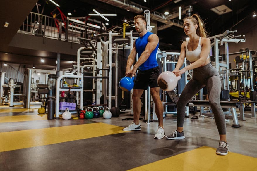 Frau und Mann im Fitnessstudio