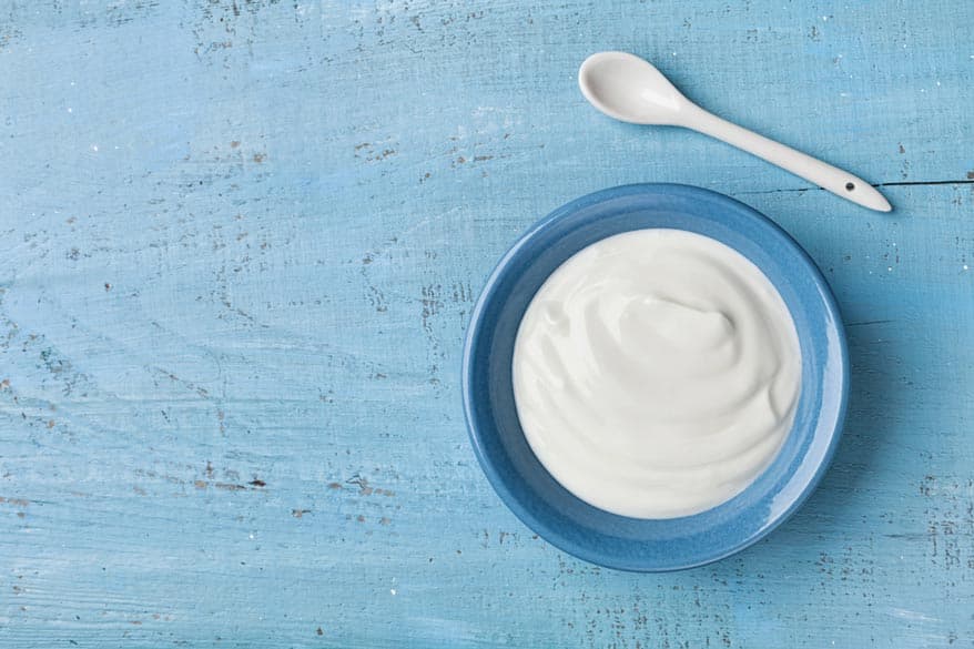 Joghurt in einer blauen Schüssel auf einem Holztisch