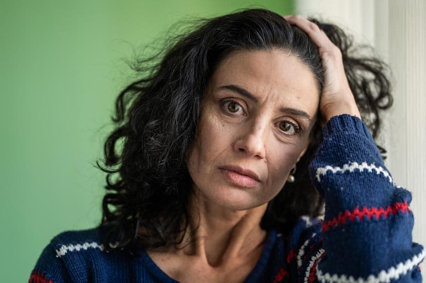 Erwachsene Frau stützt ihren Kopf