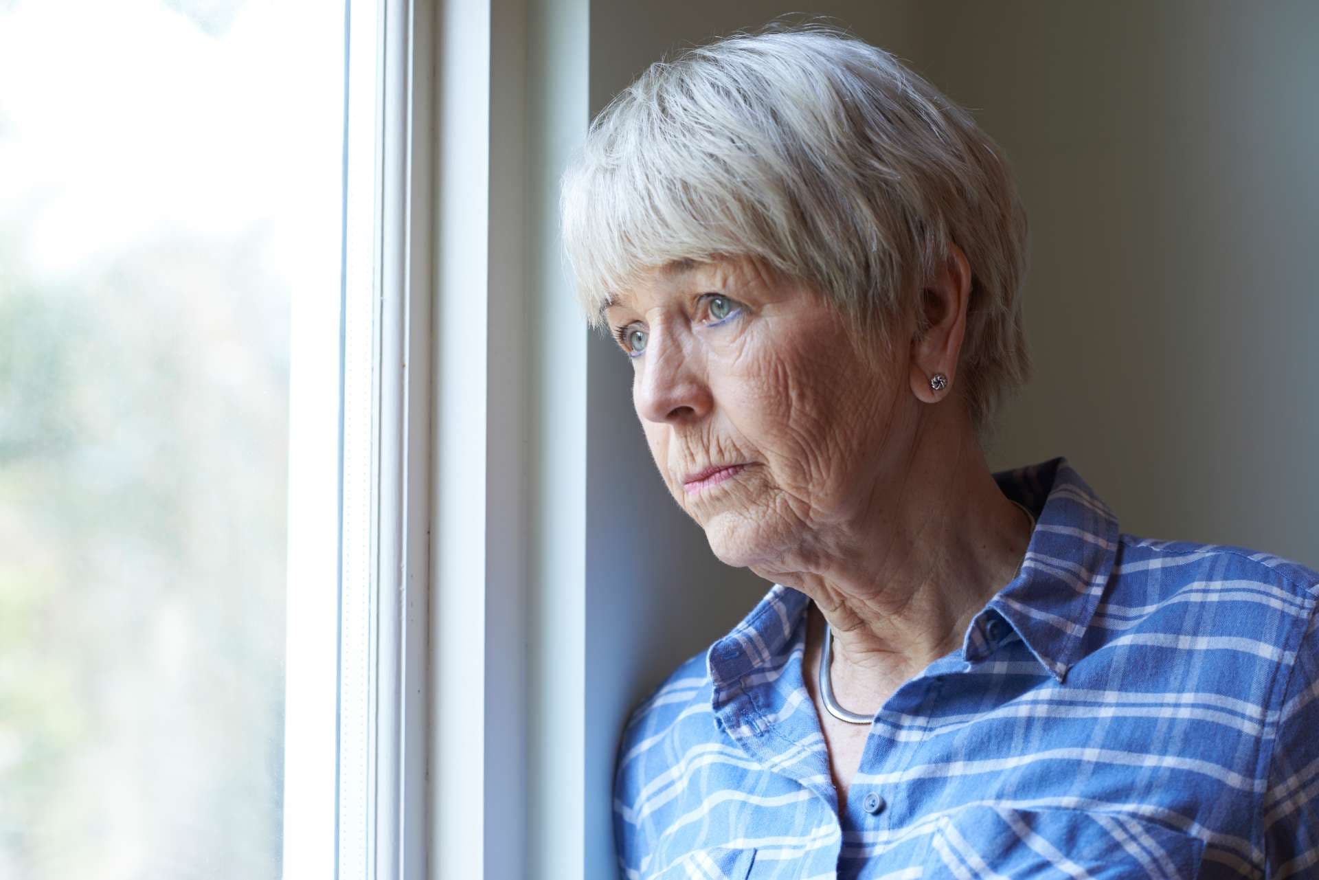 Ältere Frau leidet unter Depressionen Blick aus dem Fenster