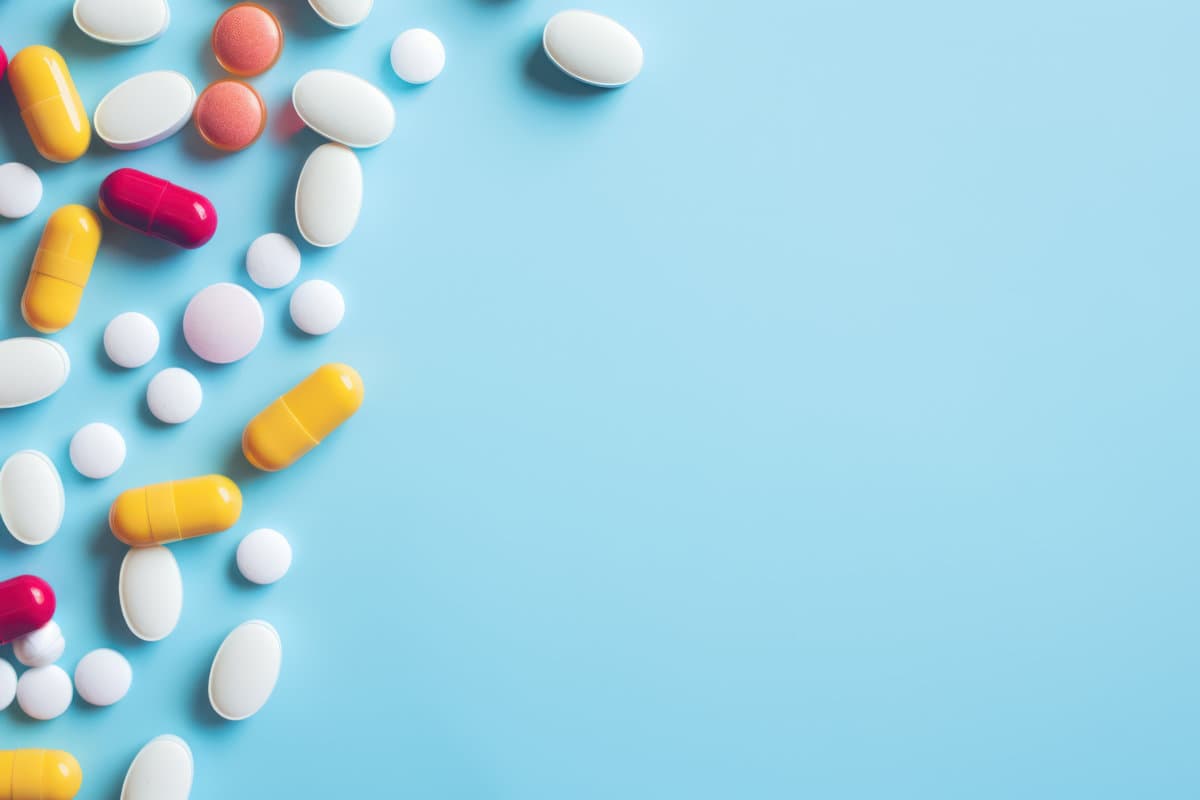 Colorful medicine tablets antibiotic pills on soft blue background