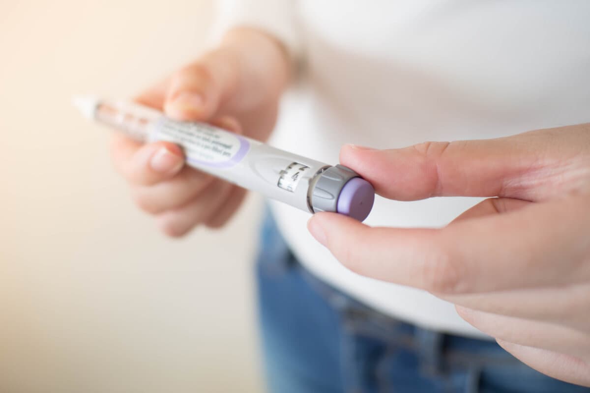 Diabetespatient dreht Knopf am Ende des Insulinpens und wählt Kor