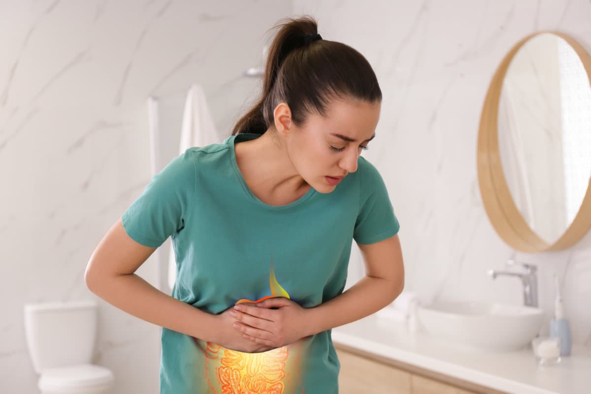 Gesundheitsdienst und Behandlung. Frau leidet unter Bauchschmerzen im Badezimmer. Illustration des Magen-Darm-Trakts