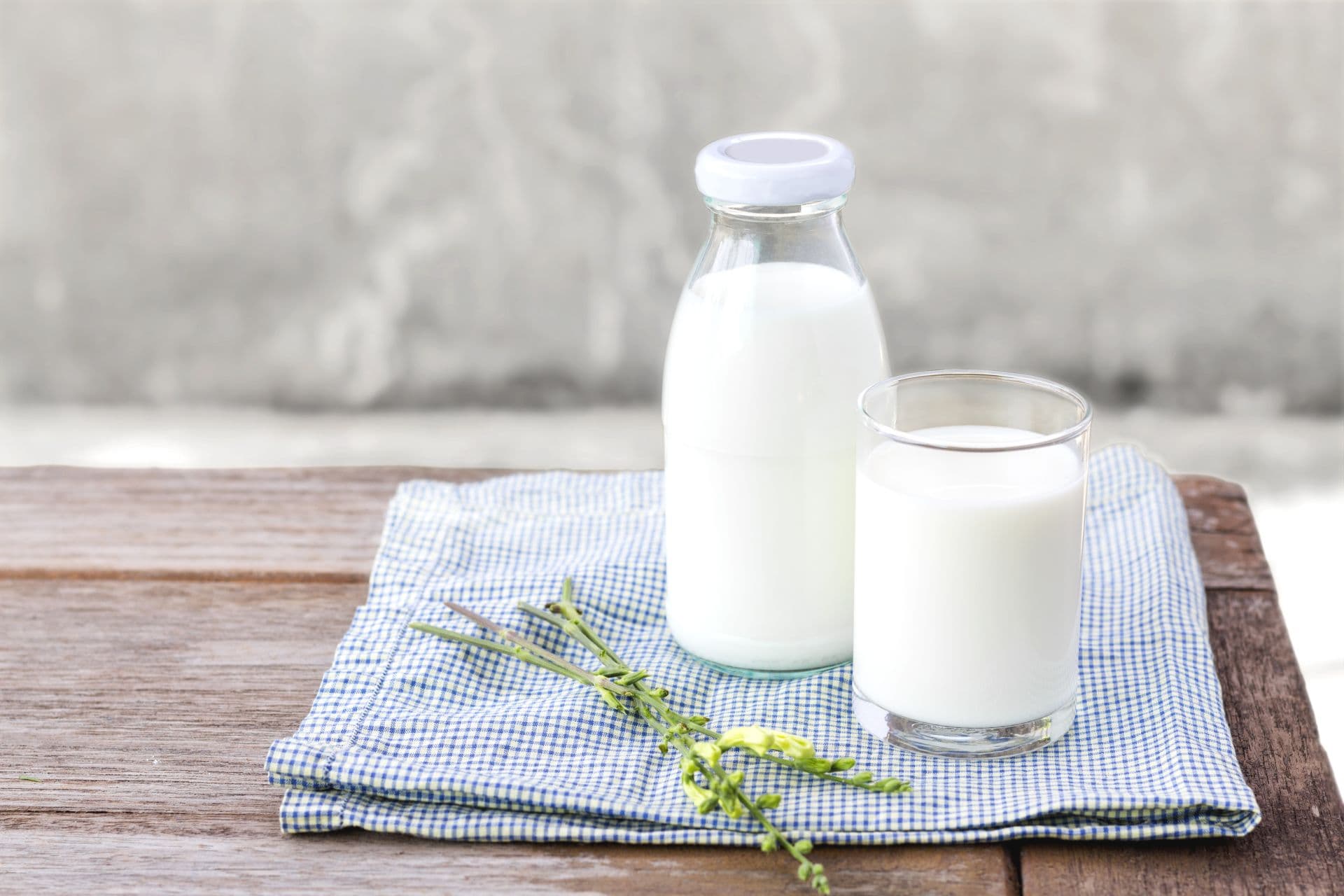 glass of milk and bottle of milk on the wood table.