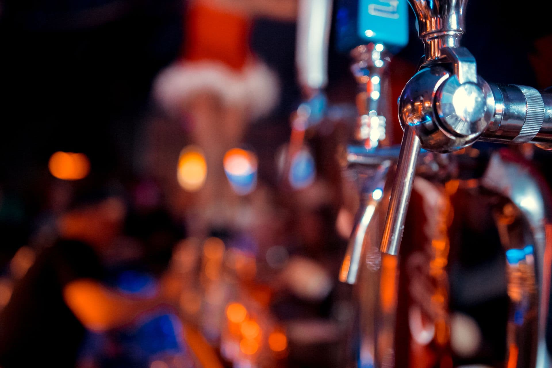 Hand of bartender pouring a large lager beer in tap. Soft, vintage instagram effect on photo. Pouring beer for client. Side view of young bartender pouring beer while standing at the bar counter