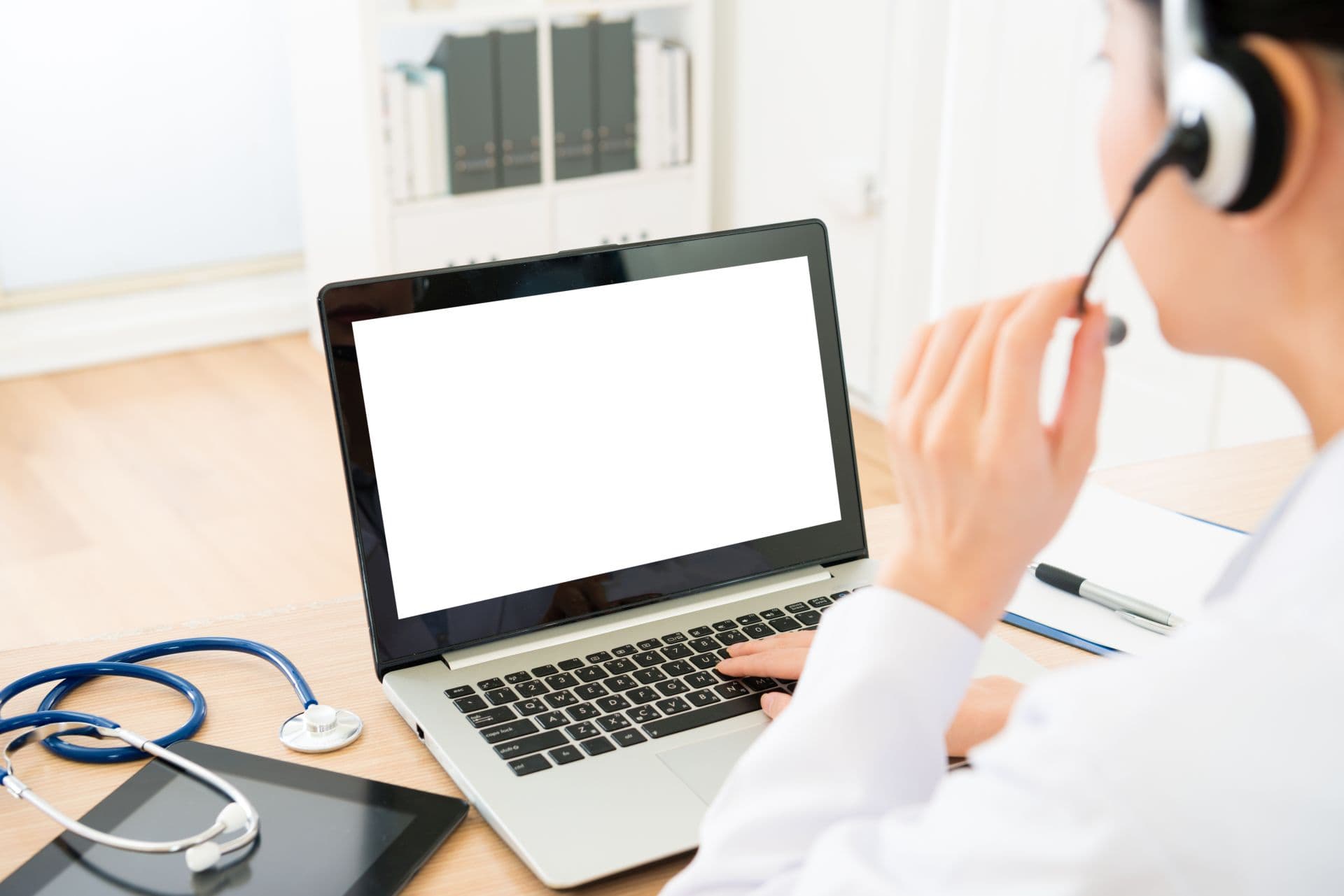 selective focus photo of female doctor wearing headphone talking with sick people and using mobile computer processed problem through online service system.