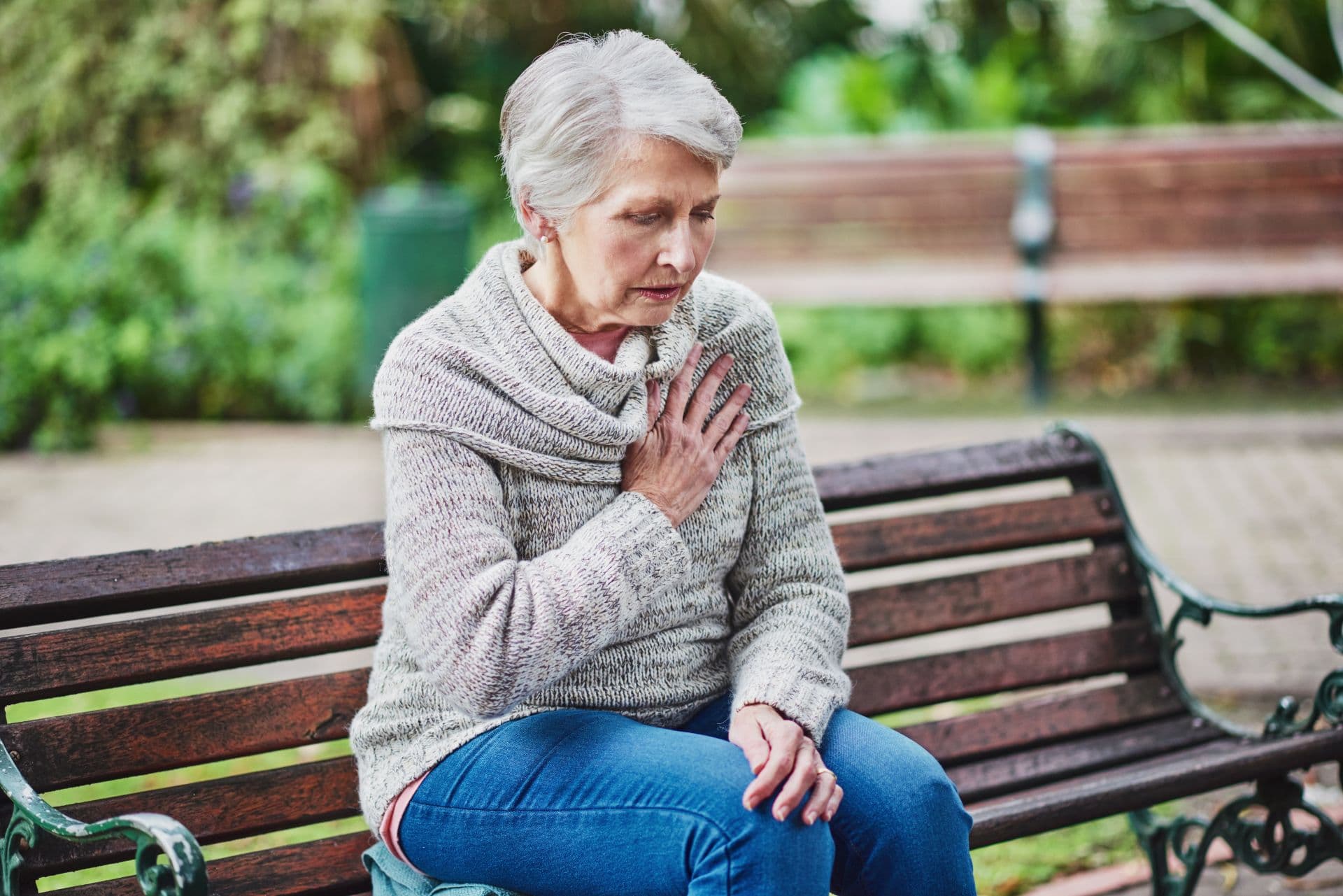 Shot of a senior woman suffering from a heart attack in the park