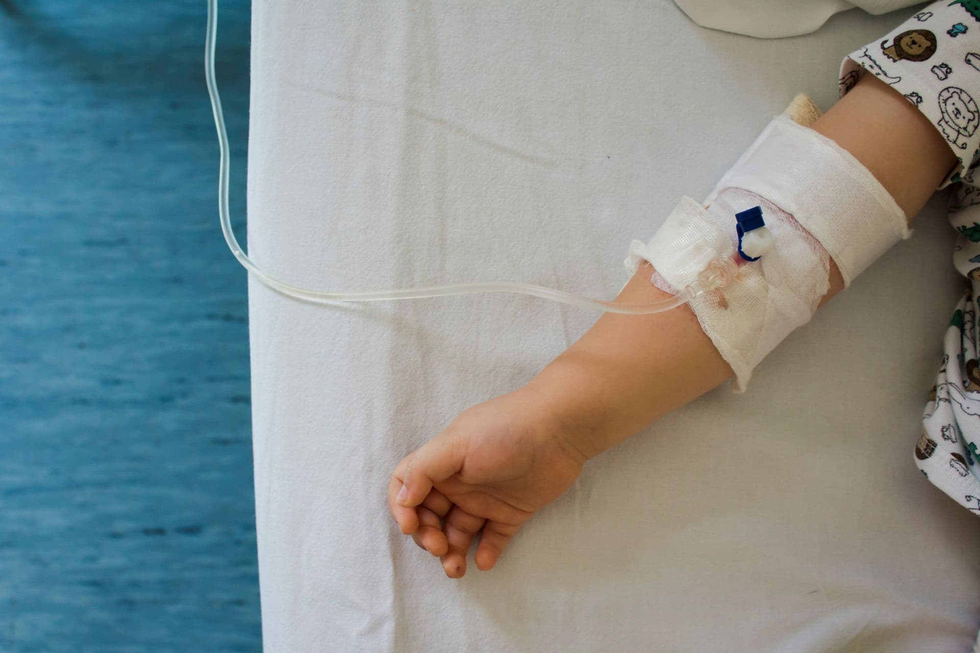 Das Kind erhält Medikamente durch intravenöse (IV) Flüssigkeitstherapie im Krankenhausbett. Erholung, Gesundheitskonzept.