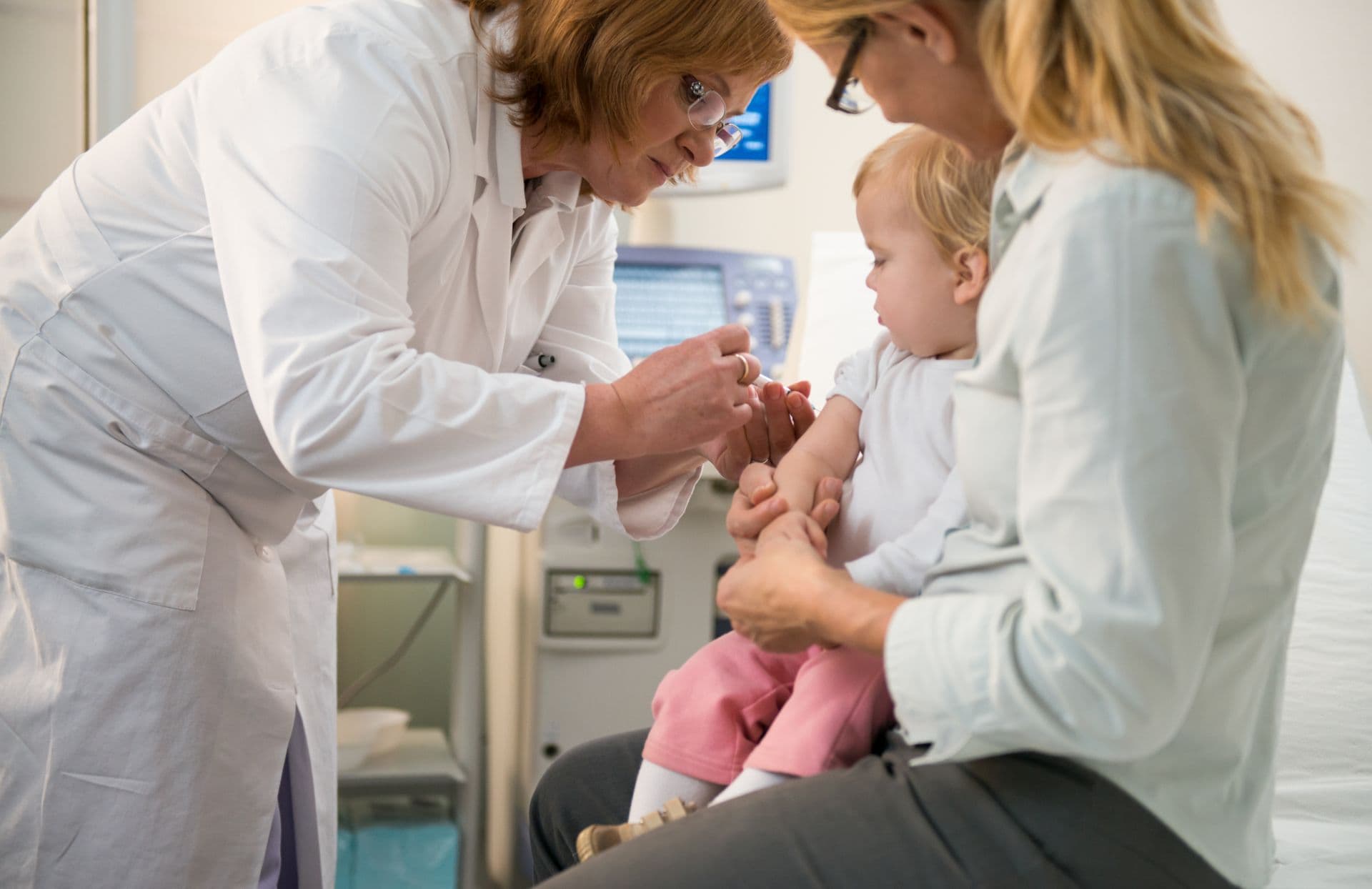 Female Doctor vaccinating small girl.