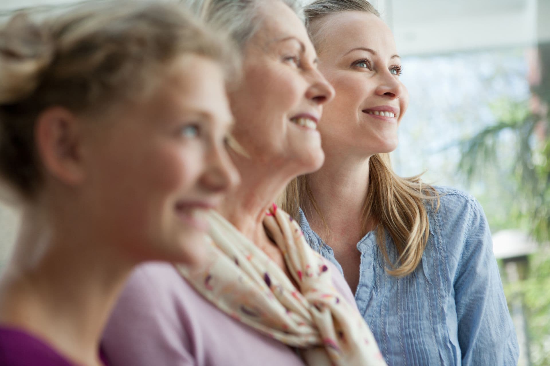 Smiling grandmother, mother and daughter looking up