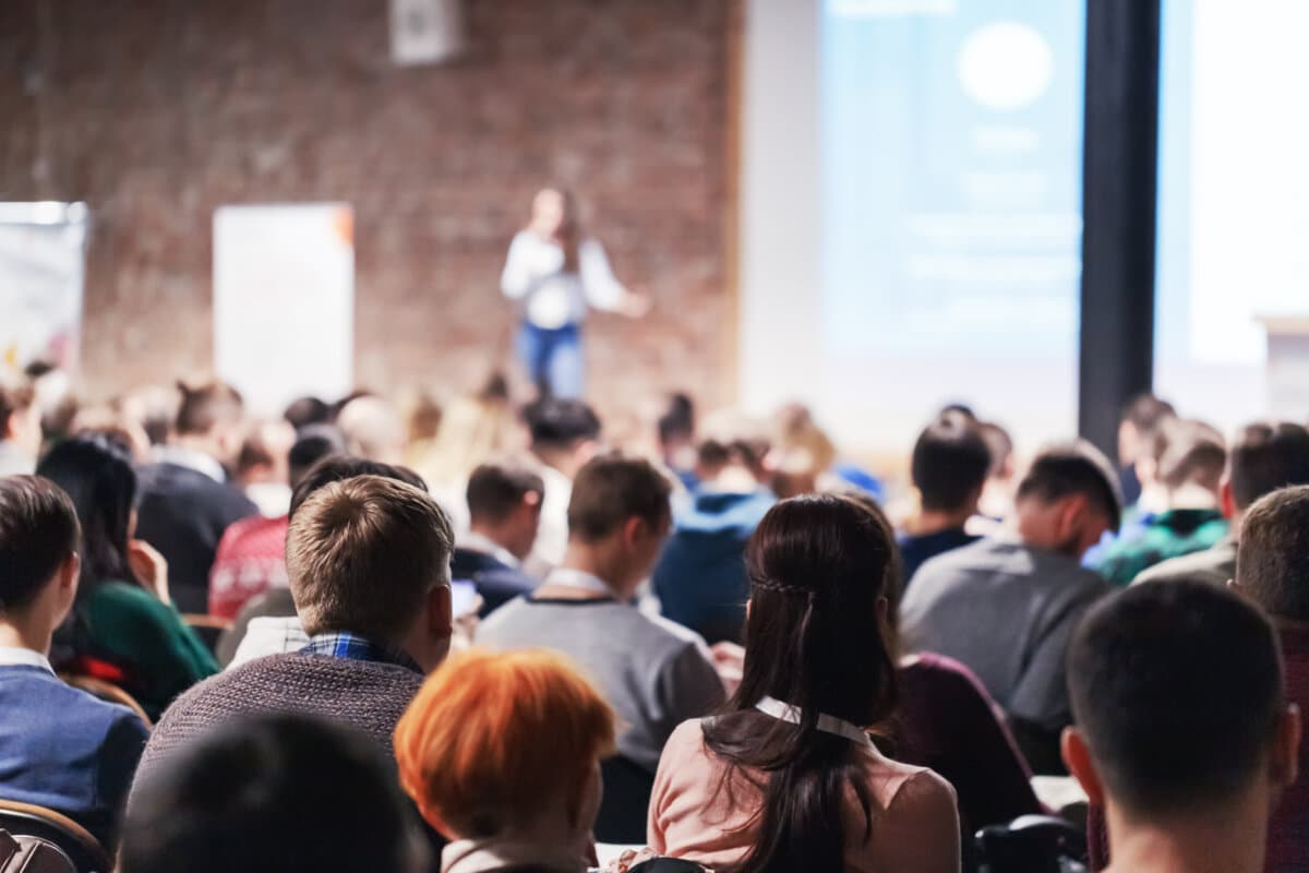 Adult people at conference listen to woman speaker providing lec