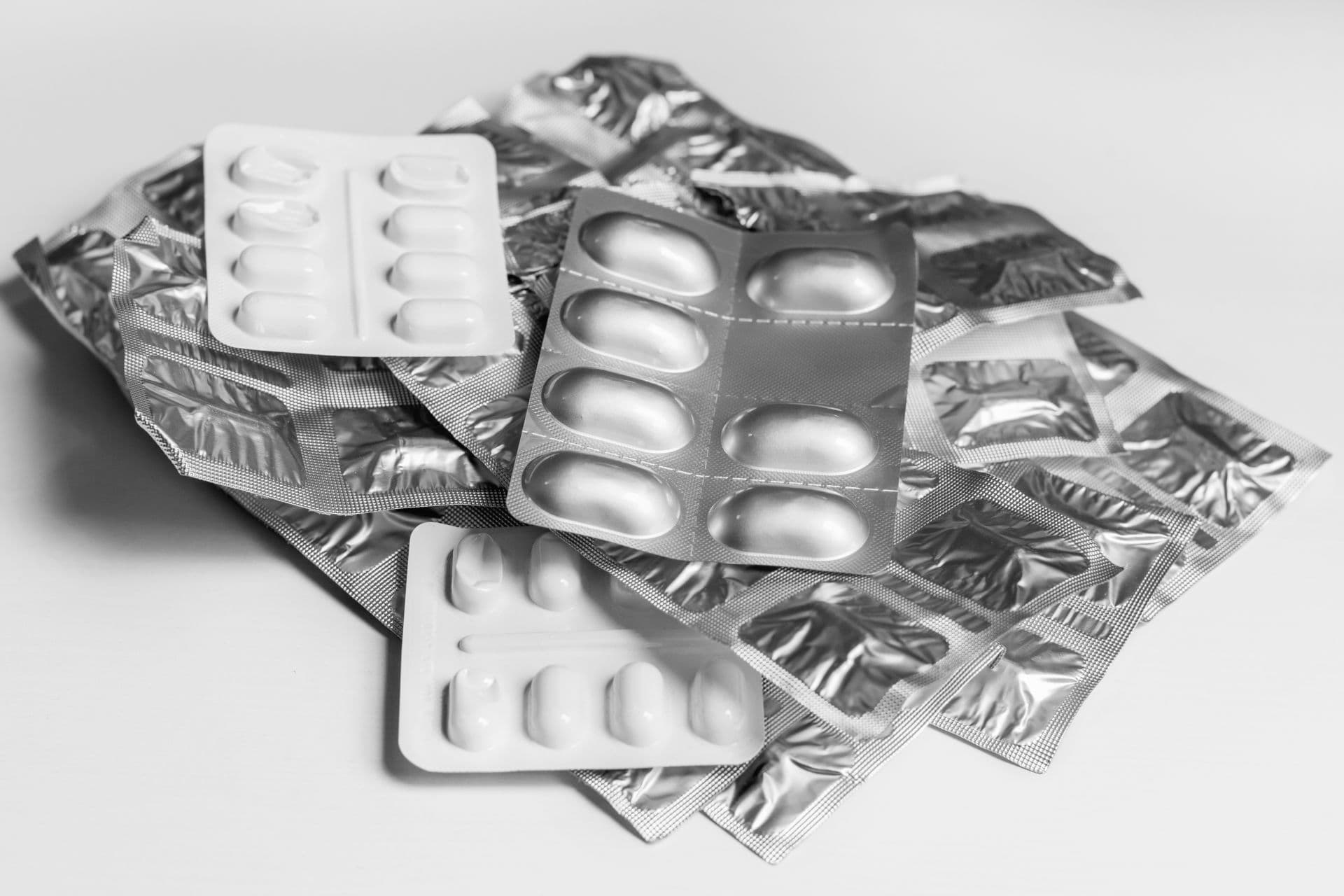 Blisterpackungen von Medizin-Tabletten in einem Stapel, auf einem einfachen Hintergrund
