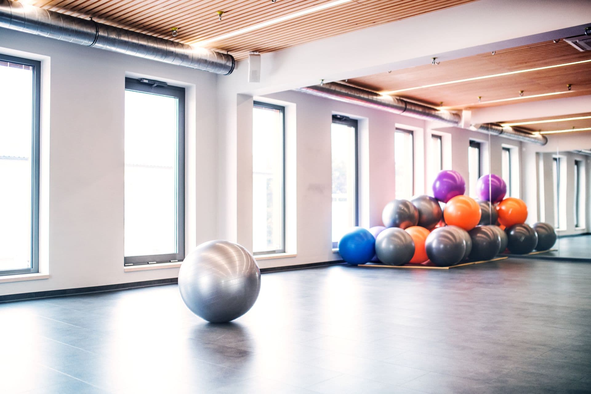 Junge schöne Frau, die Übung mit einem fitball in einer Turnhalle tut.