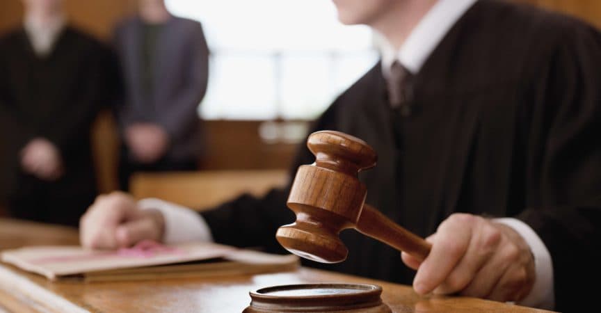 Judge holding gavel in courtroom