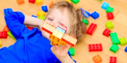 child playing with colorful plastic blocks indoor