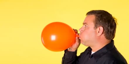 Man blowing up balloon