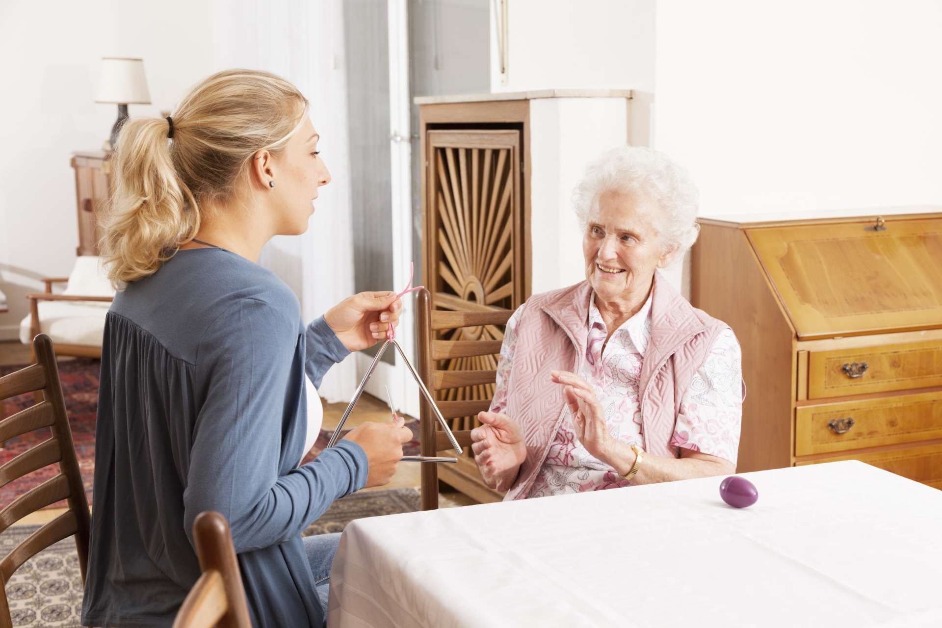 caregiver doing music therapy with senior woman