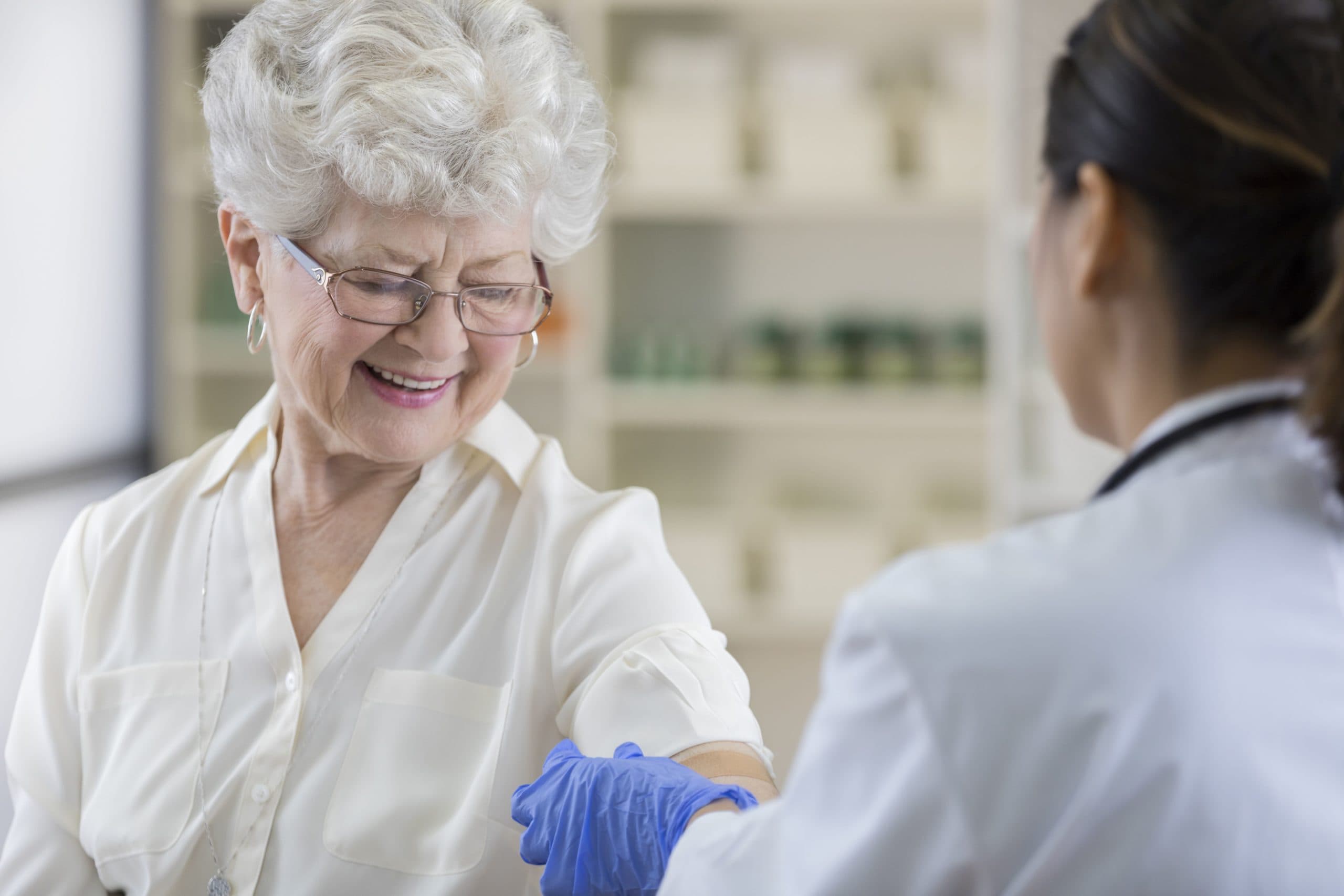 Senior Apothekenkunde bekommt nach Grippeschutzimpfung ein Pflaster