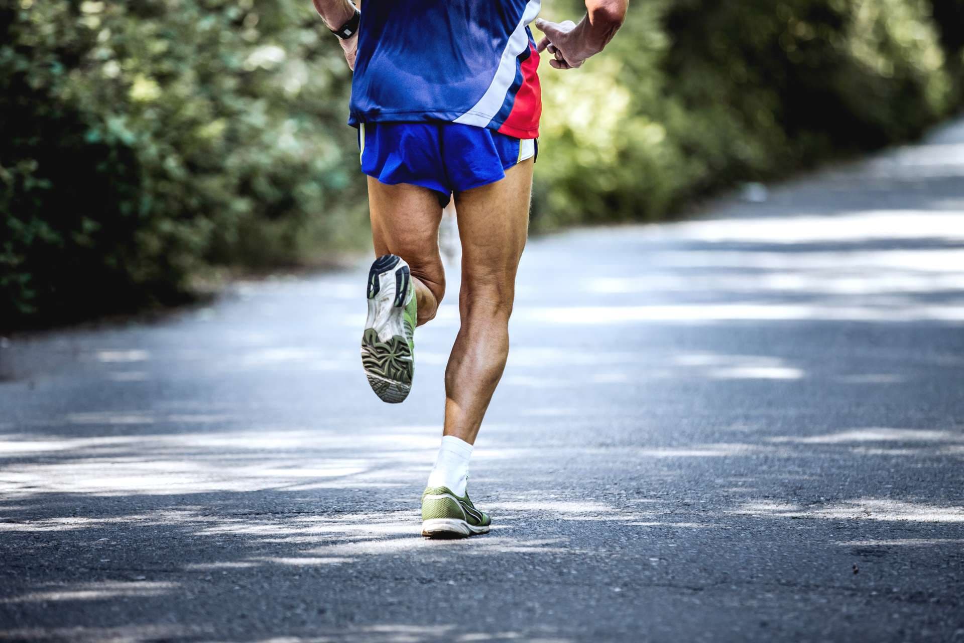 Tscheljabinsk, Russland - 9. Juli 2016: Füße alter männlicher Athlet läuft auf der Straße im Wald während des Sommerhalbmarathons