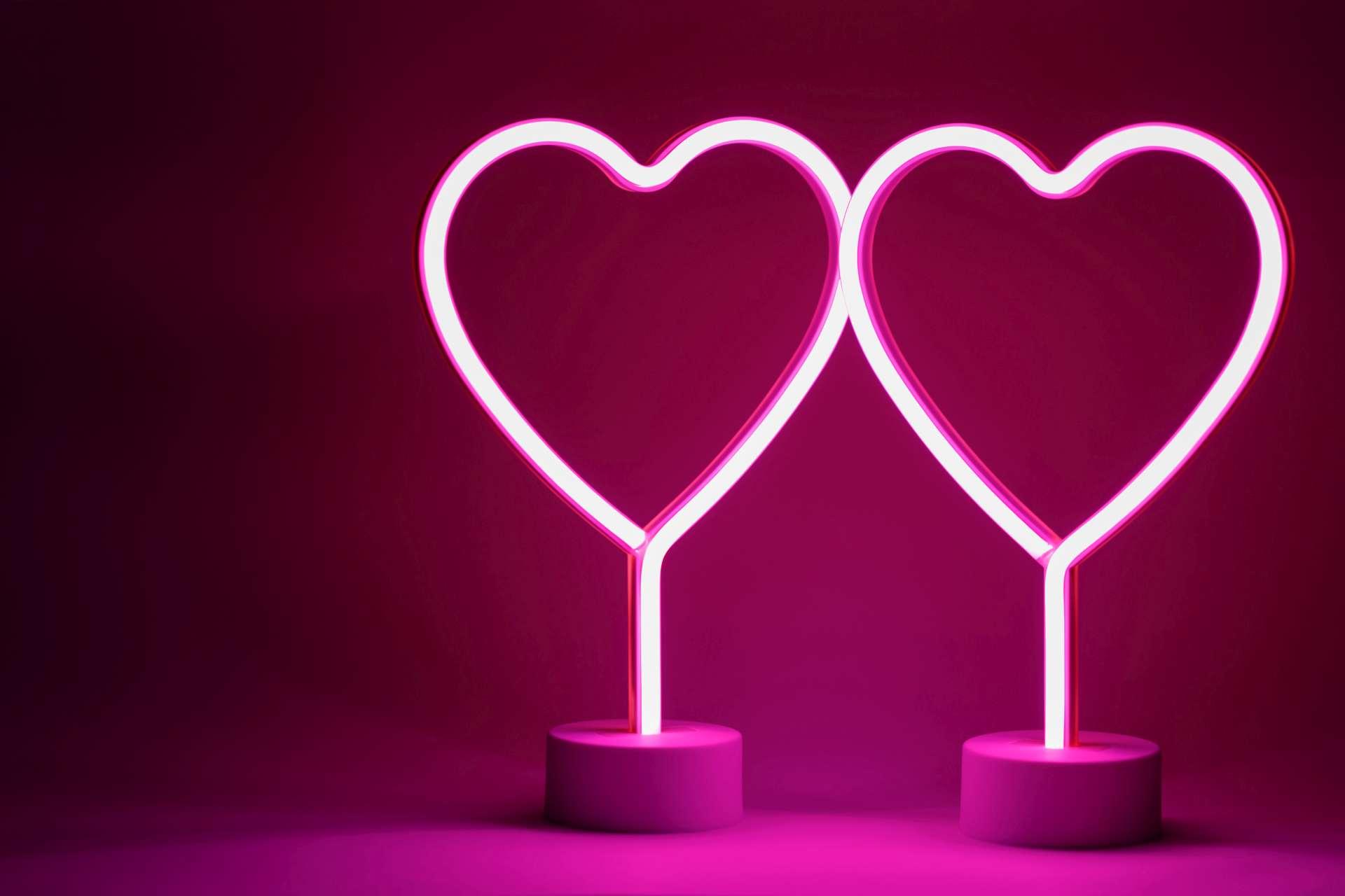 Zwei leuchtende rosa Neonherzen Valentinstag-Party-Konzept