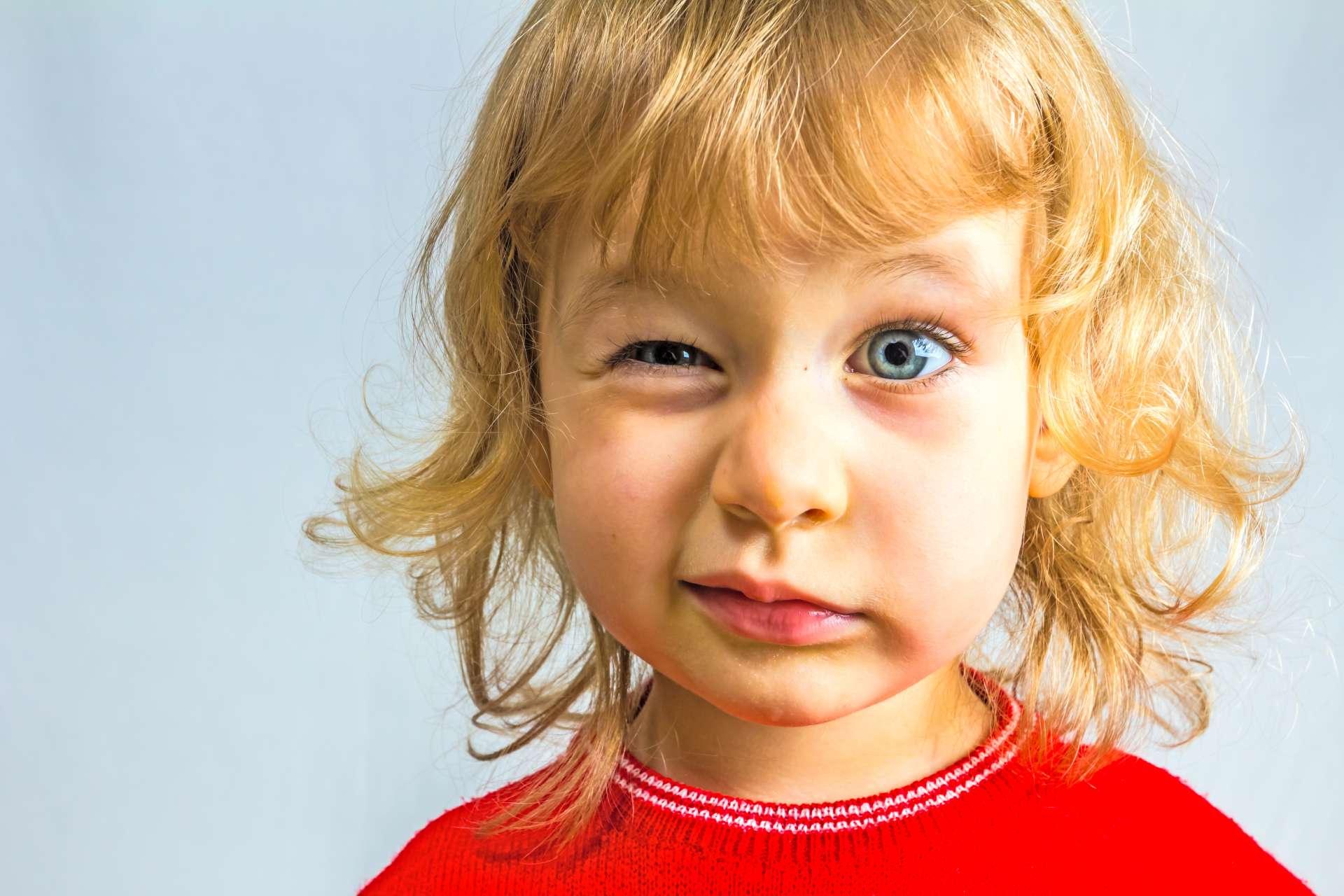 Blauäugiges, 3-jähriges Mädchen im roten Kleid