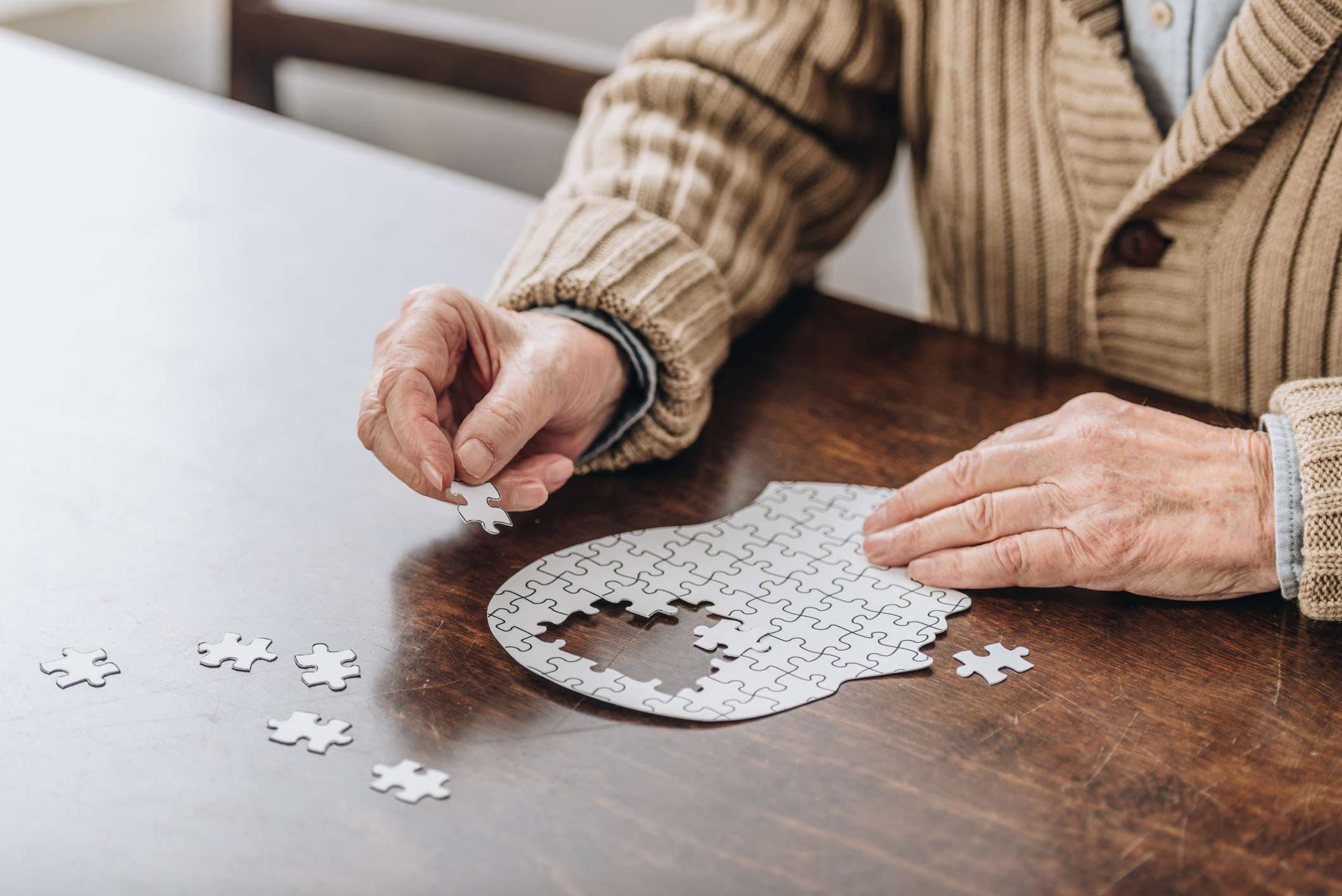 beschnittene Ansicht des älteren Mannes, der mit Rätseln spielt