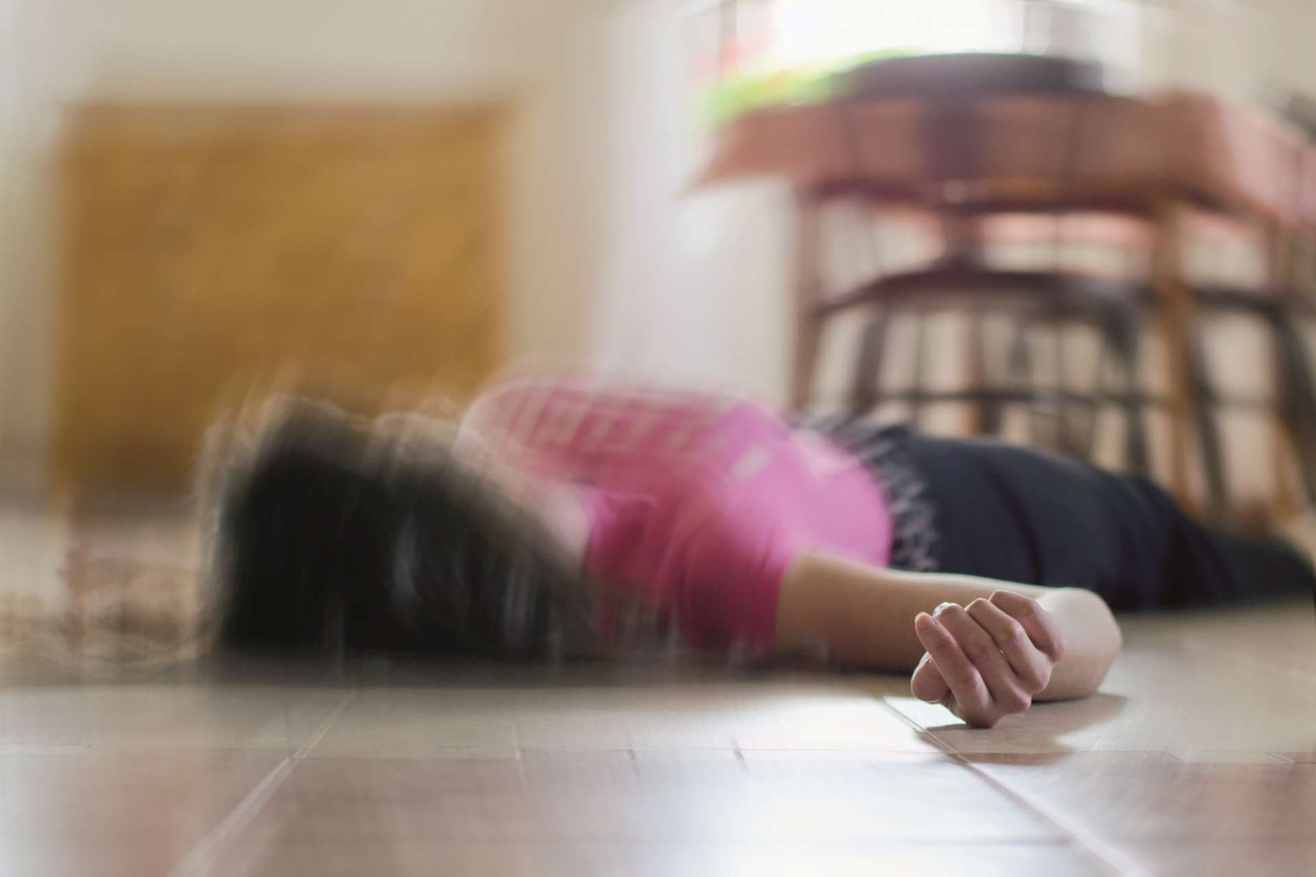 Frau, die zu Hause auf dem Boden liegt, Epilepsie, Bewusstlosigkeit, Ohnmacht, Schlaganfall, Unfall oder andere gesundheitliche Probleme.