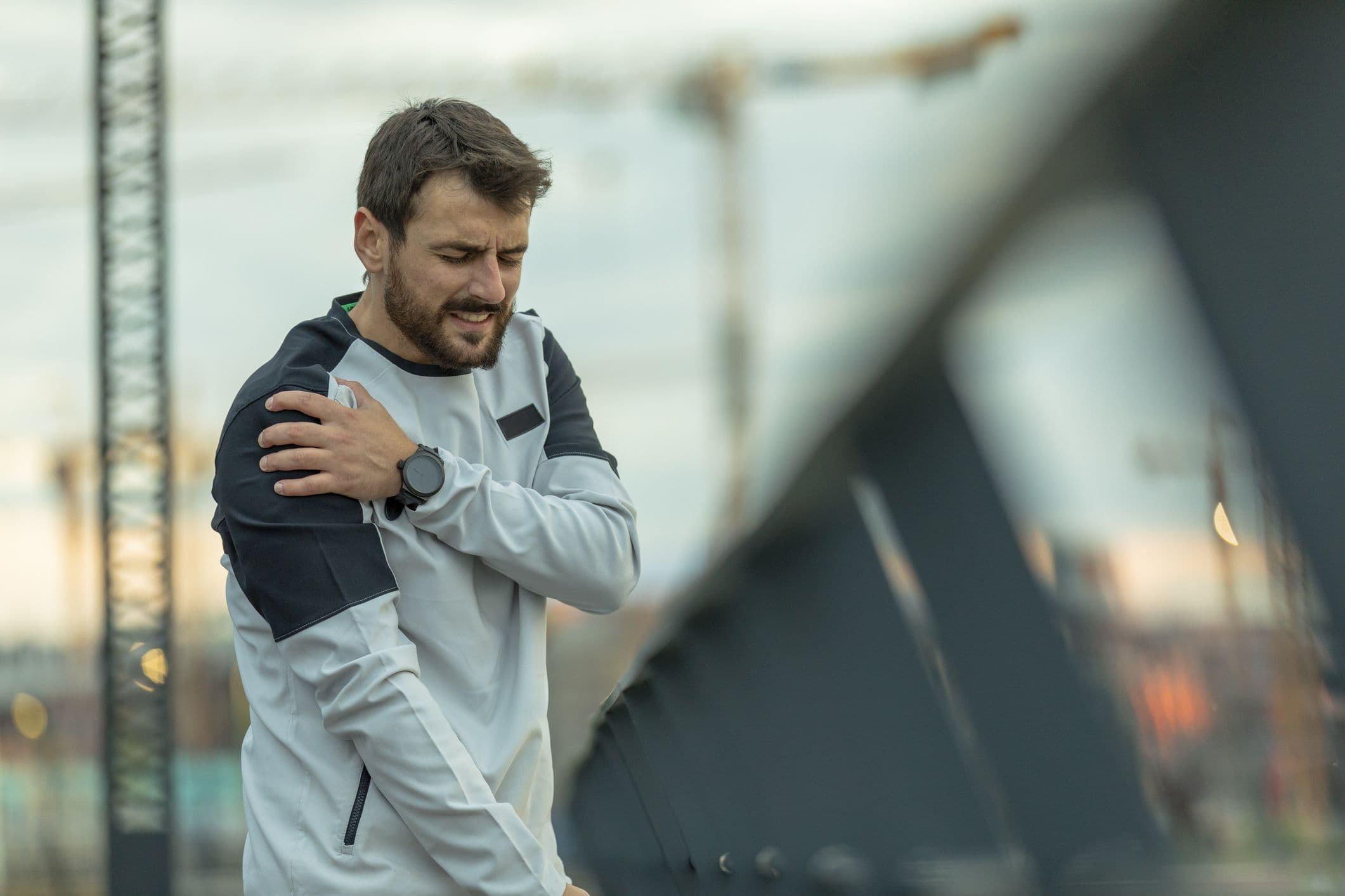 Hübscher junger Sportler hat während eines Trainings eine körperliche Verletzung der Schulter