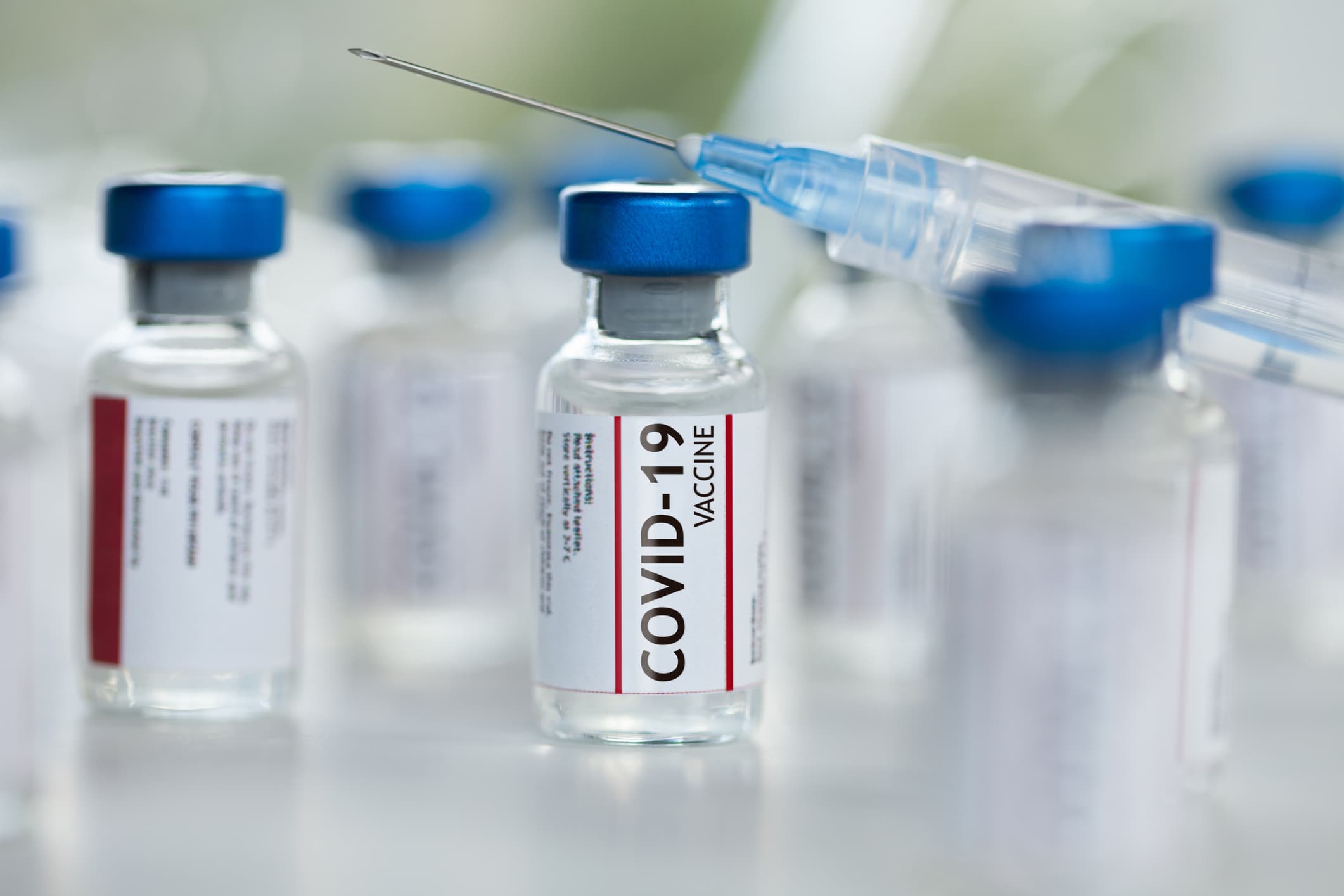 Covid-19 Coronavirus-Impfstoffflaschen mit Spritzenmakro-Nahaufnahme, flachem Fokus