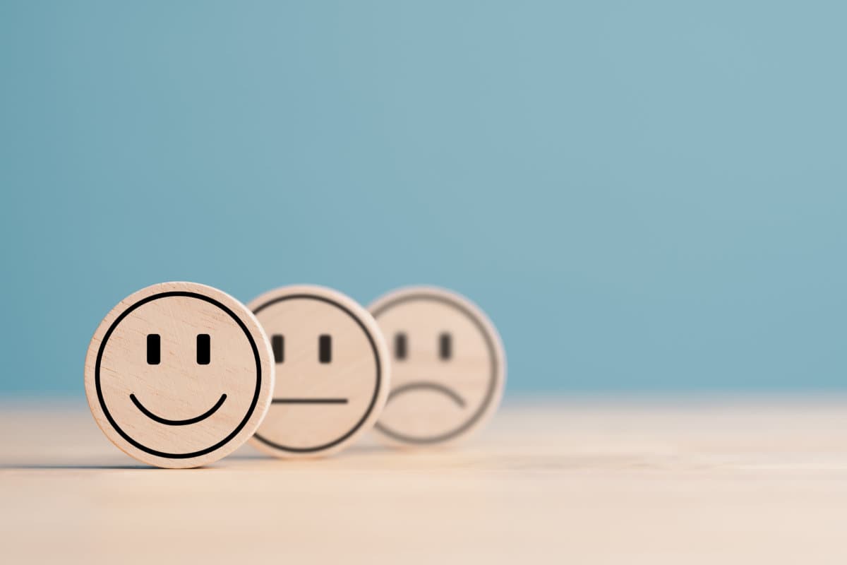 Wooden label with happy normal and sad face icons for experience survey services and products review concept. Customer or Client show Good Neutral or Negative feedback and satisfaction rating.