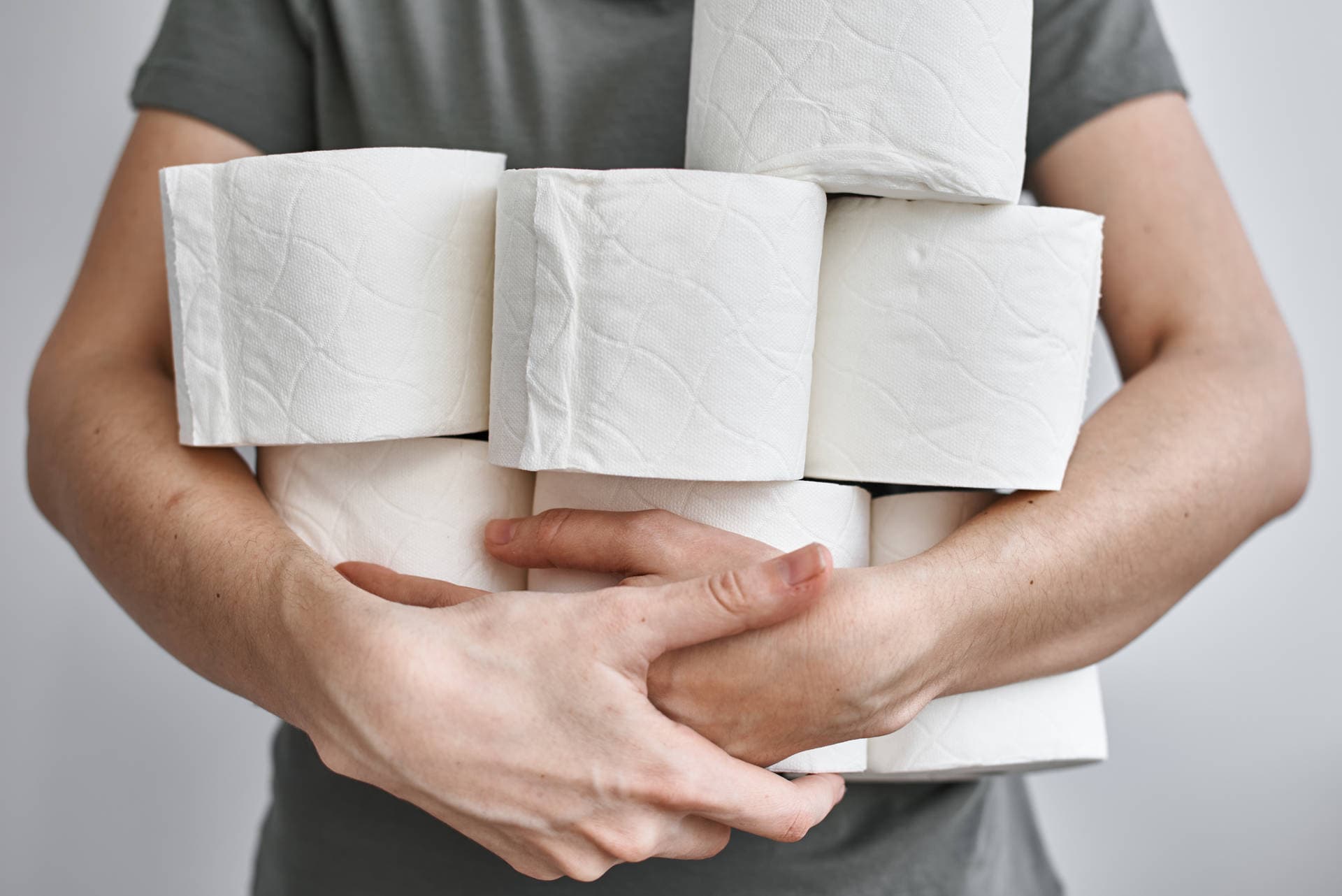 Die Leute füllen Toilettenpapier für die Heimquarantäne von Crownavirus auf. Frau hält viele Rollen Toilettenpapier
