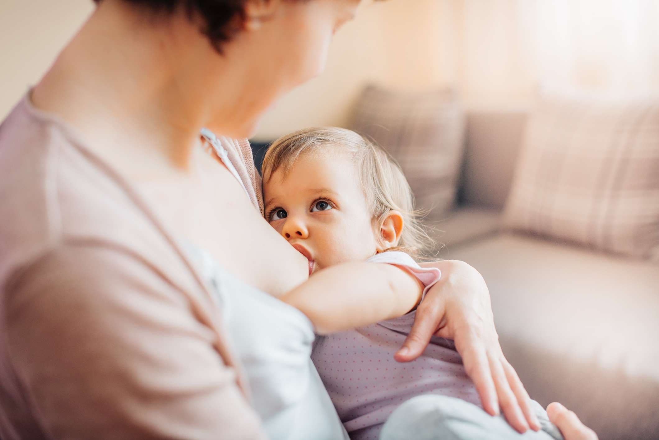 Mutter, die Kleinkindtochter stillt