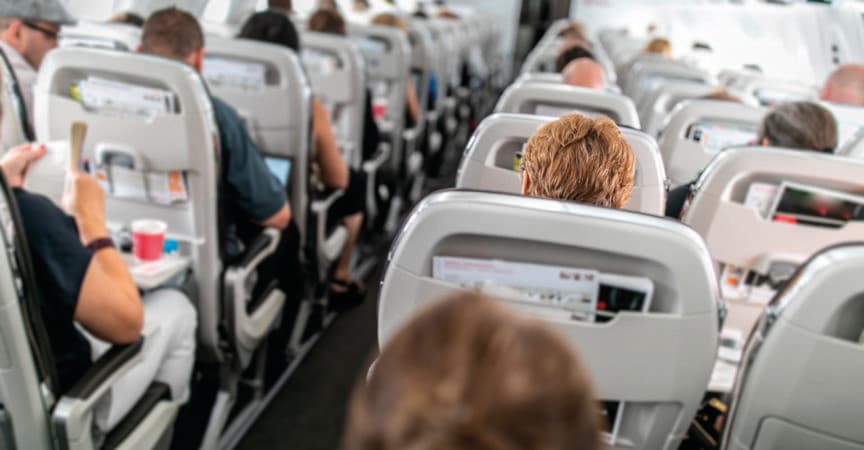 Innenraum eines Verkehrsflugzeugs mit Passagieren in ihren Sitzen während des Fluges.