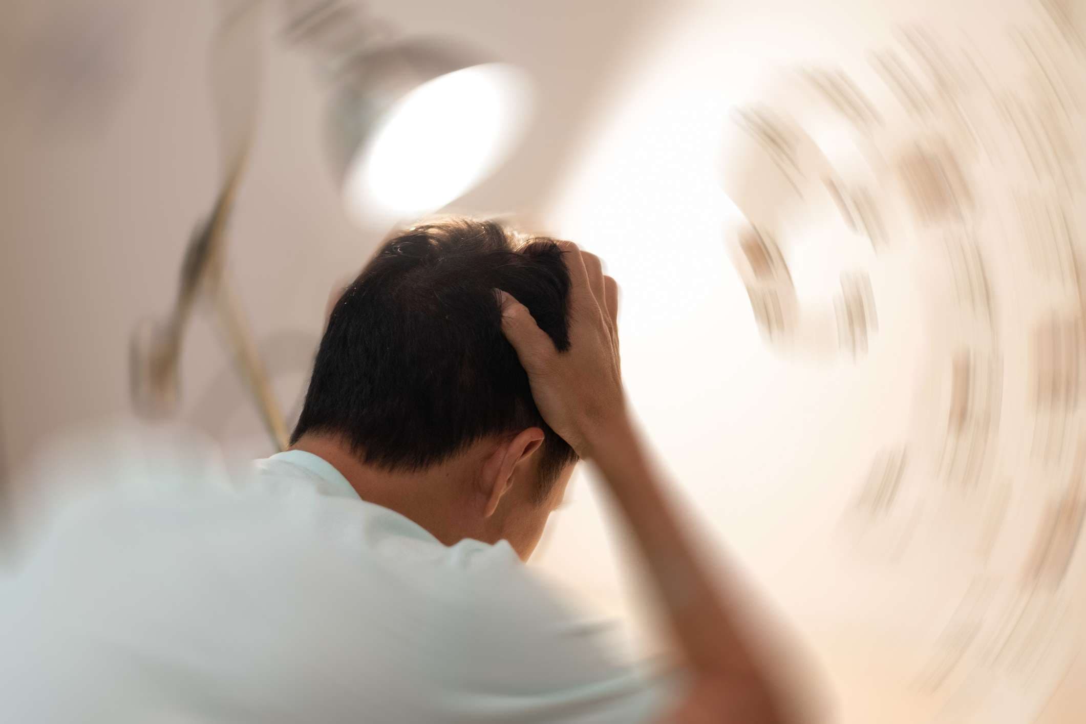Konzept der Schwindelkrankheit. Mann Hände auf den Kopf fallen Kopfschmerzen Schwindelgefühl Drehschwindel, ein Problem mit dem Innenohr, dem Gehirn oder der sensorischen Nervenbahn.