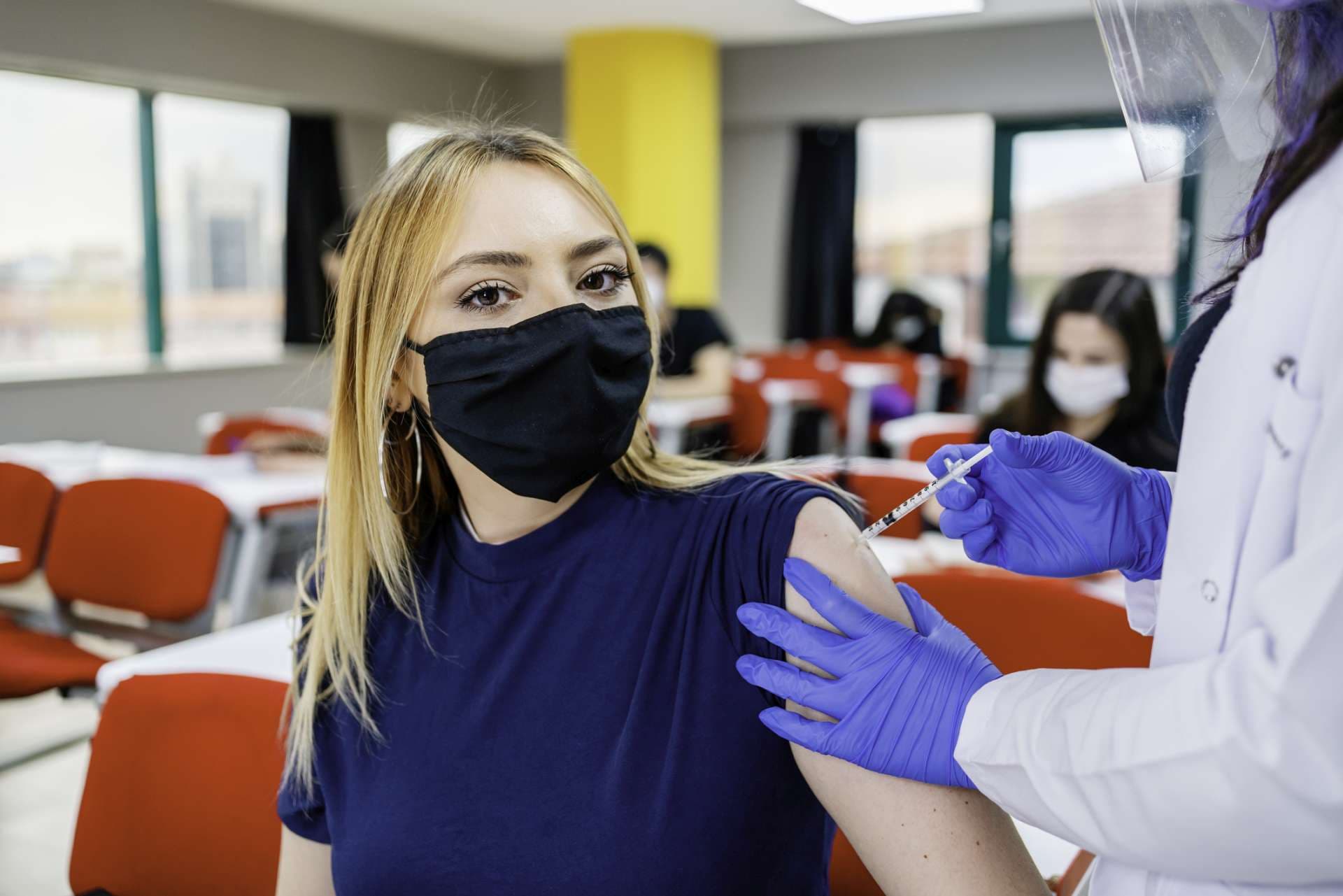 Krankenschwester gibt Schülern während der Coronavirus-Pandemie eine Impfung in der Schule