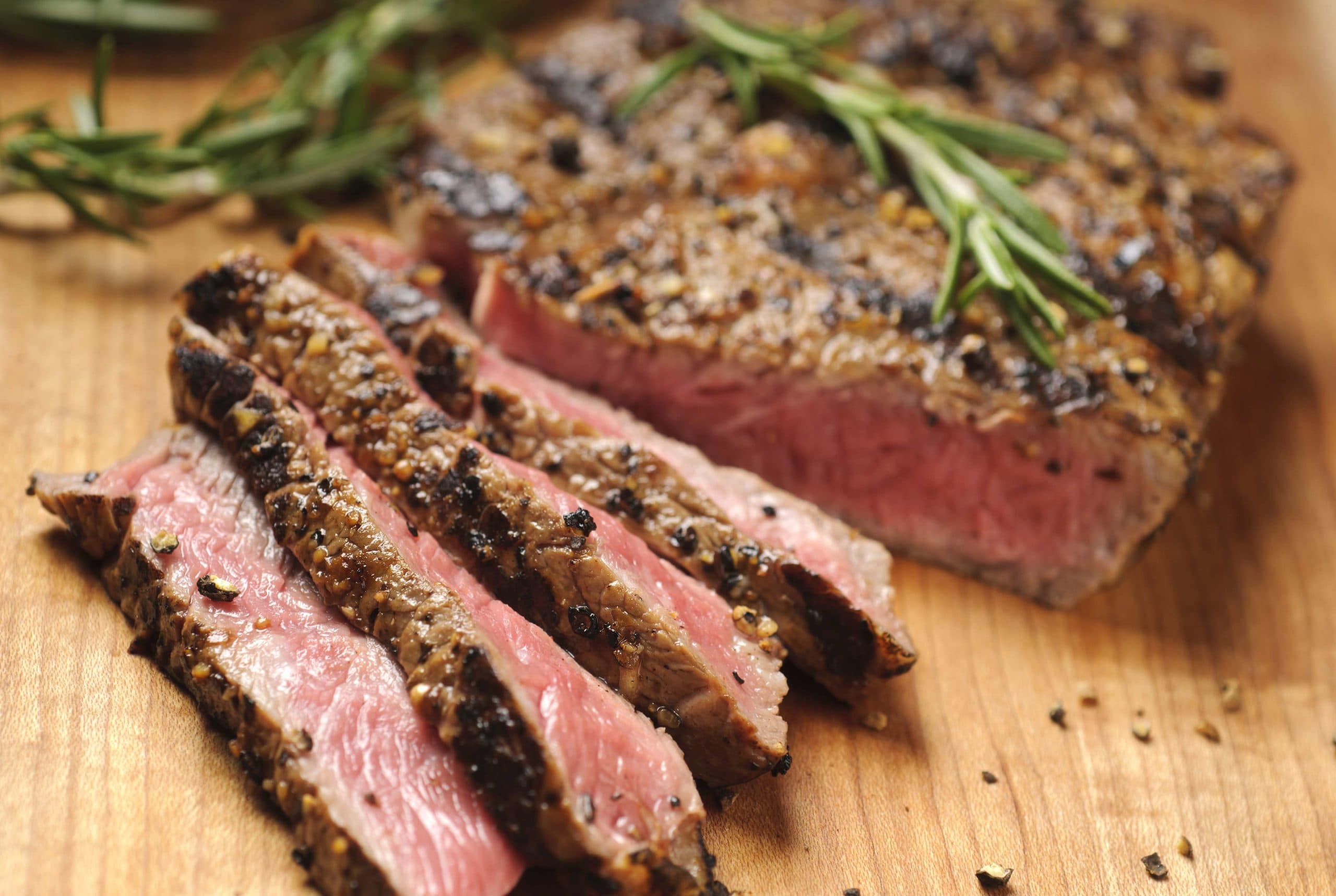 Gegrilltes Steak wird auf einem Schneidebrett in Scheiben geschnitten. Bitte sehen Sie mein Portfolio für andere lebensmittelbezogene Bilder.