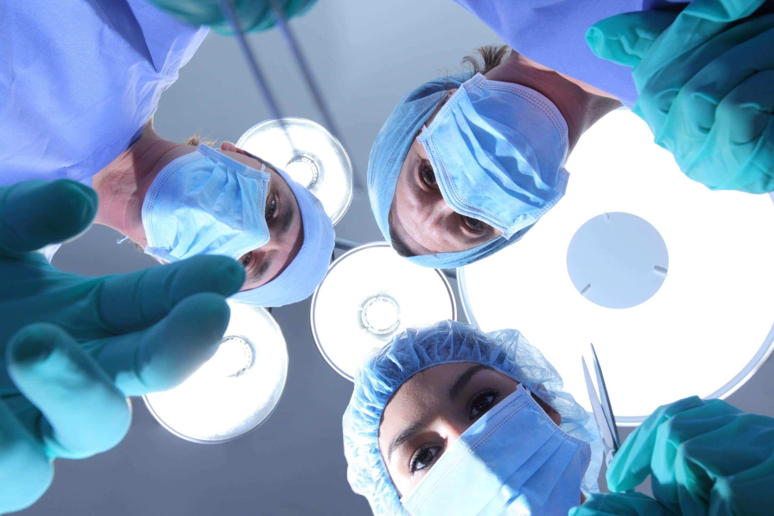 Gruppe von Chirurgen, die auf den Patienten herabblicken