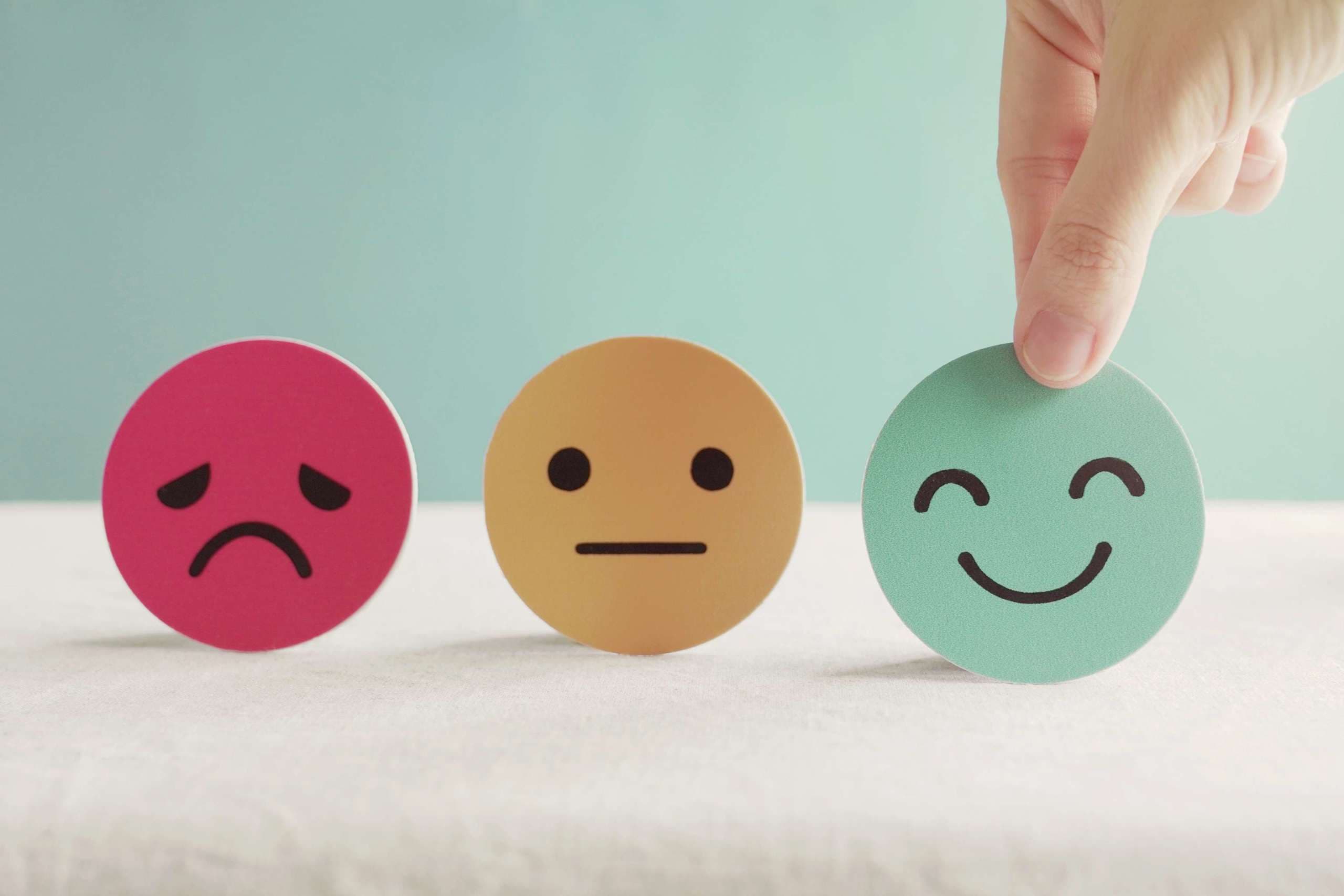 Hand, die grünes glückliches Smiley-Gesichtspapierschnitt, Produkt, Benutzer, Service-Feedback-Bewertung und Kundenbewertung, Erfahrung, Zufriedenheitsumfrage, psychologisches Testkonzept für psychische Gesundheit wählt