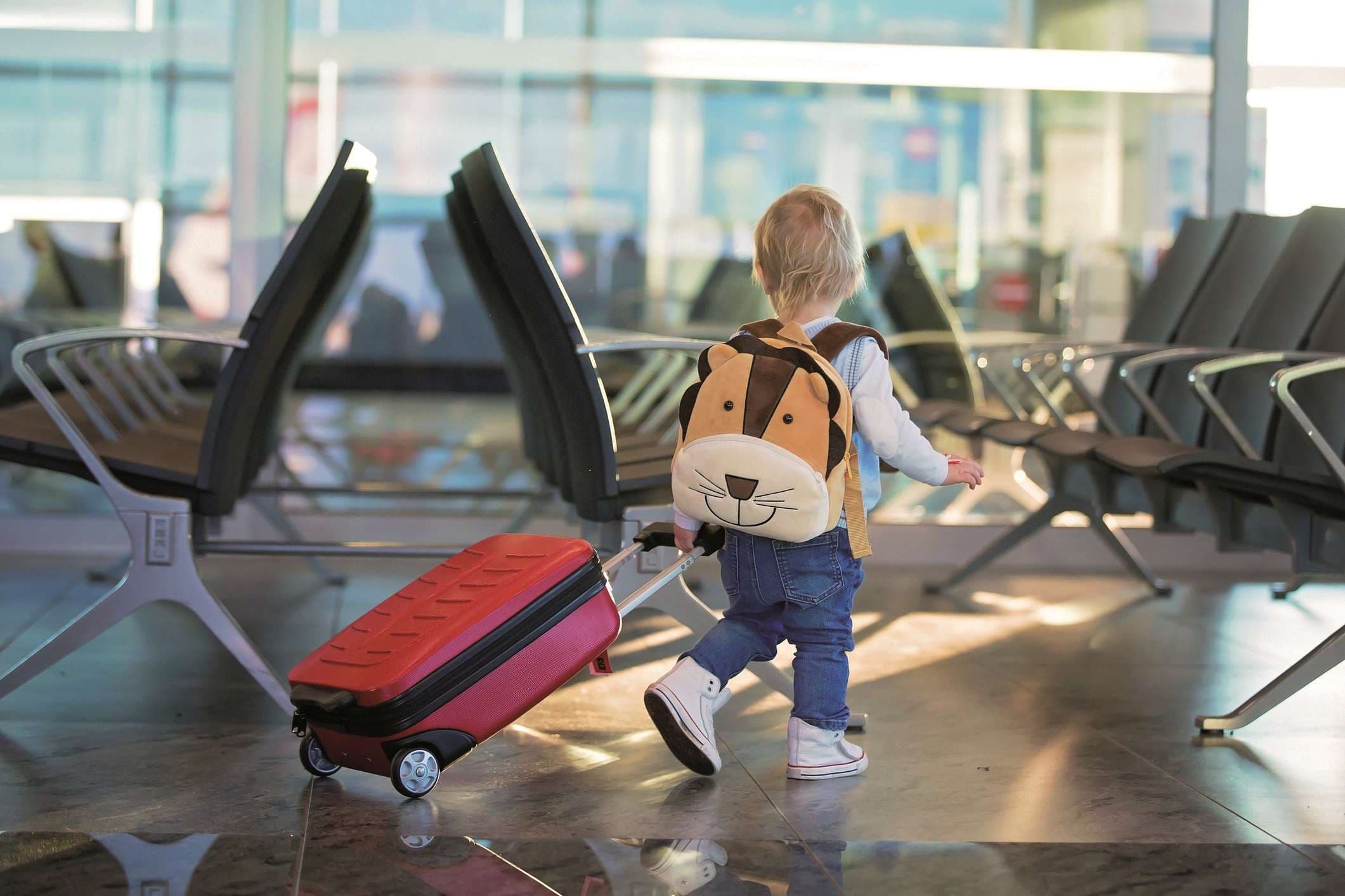 Kinder, die zusammen reisen, am Flughafen warten, um das Flugzeug zu besteigen