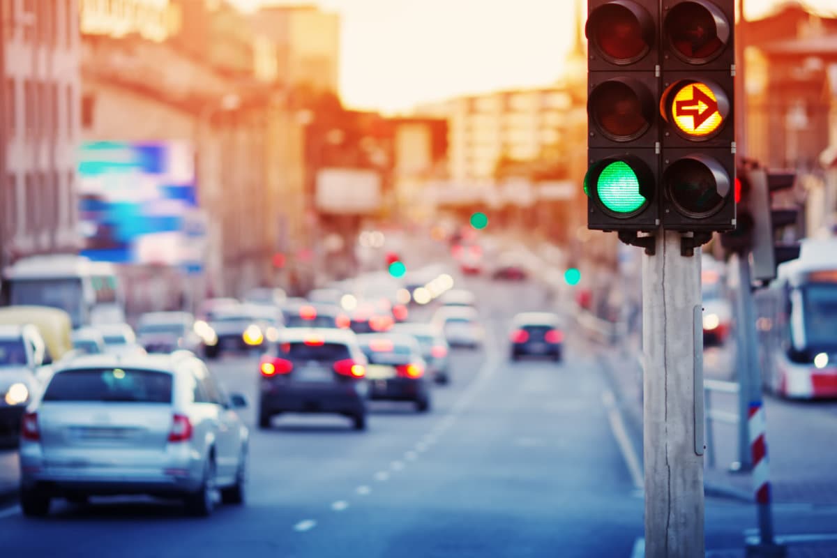 Cars moving on the road in city in late evening. View to the traffic with trafficlights and transport