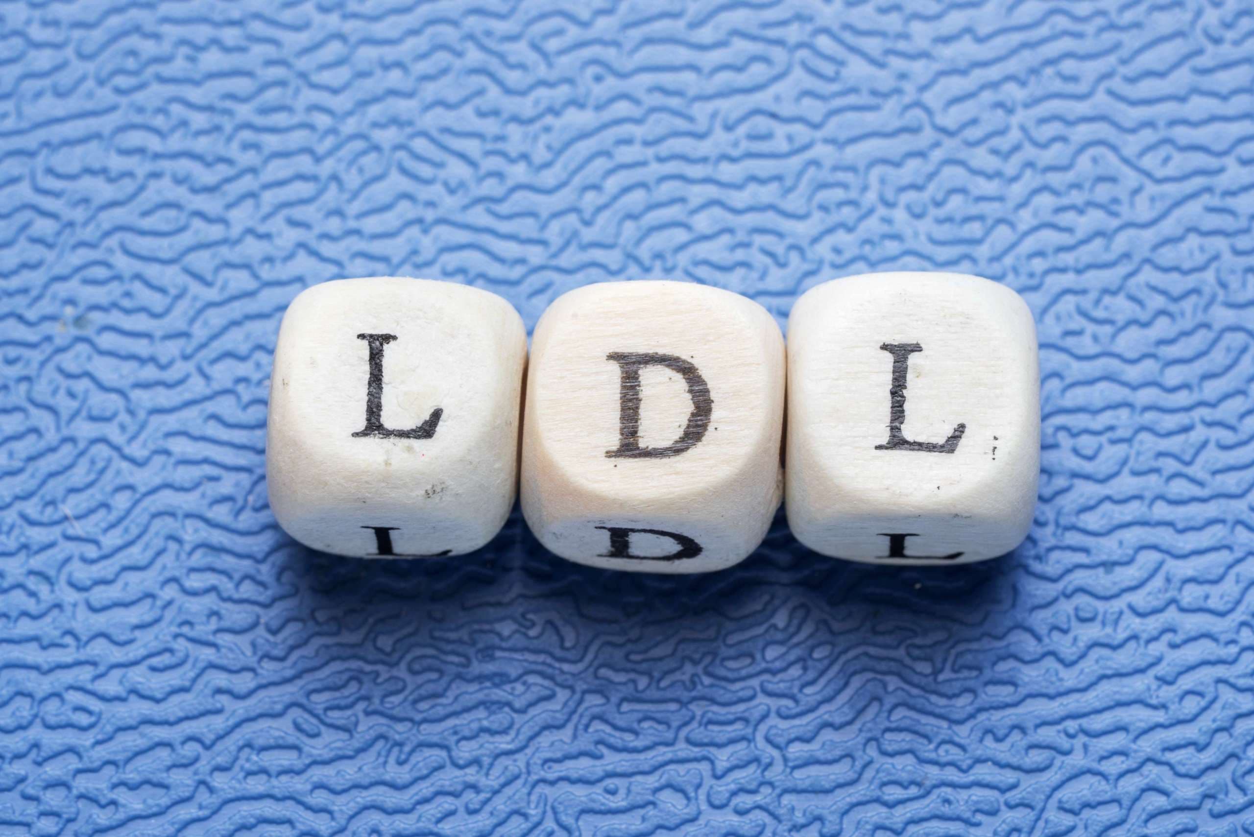 Wort ldl (Low Density Lipoprotein) auf einem Holzwürfel auf blauem Hintergrund
