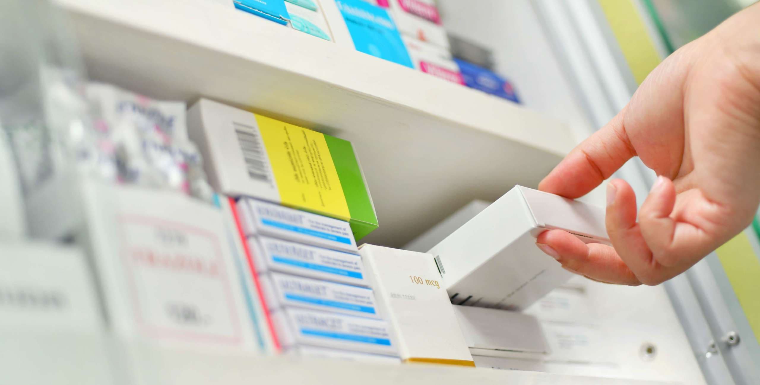 Closeup Apotheker Hand hält Medizinbox in der Apotheke Drogerie.