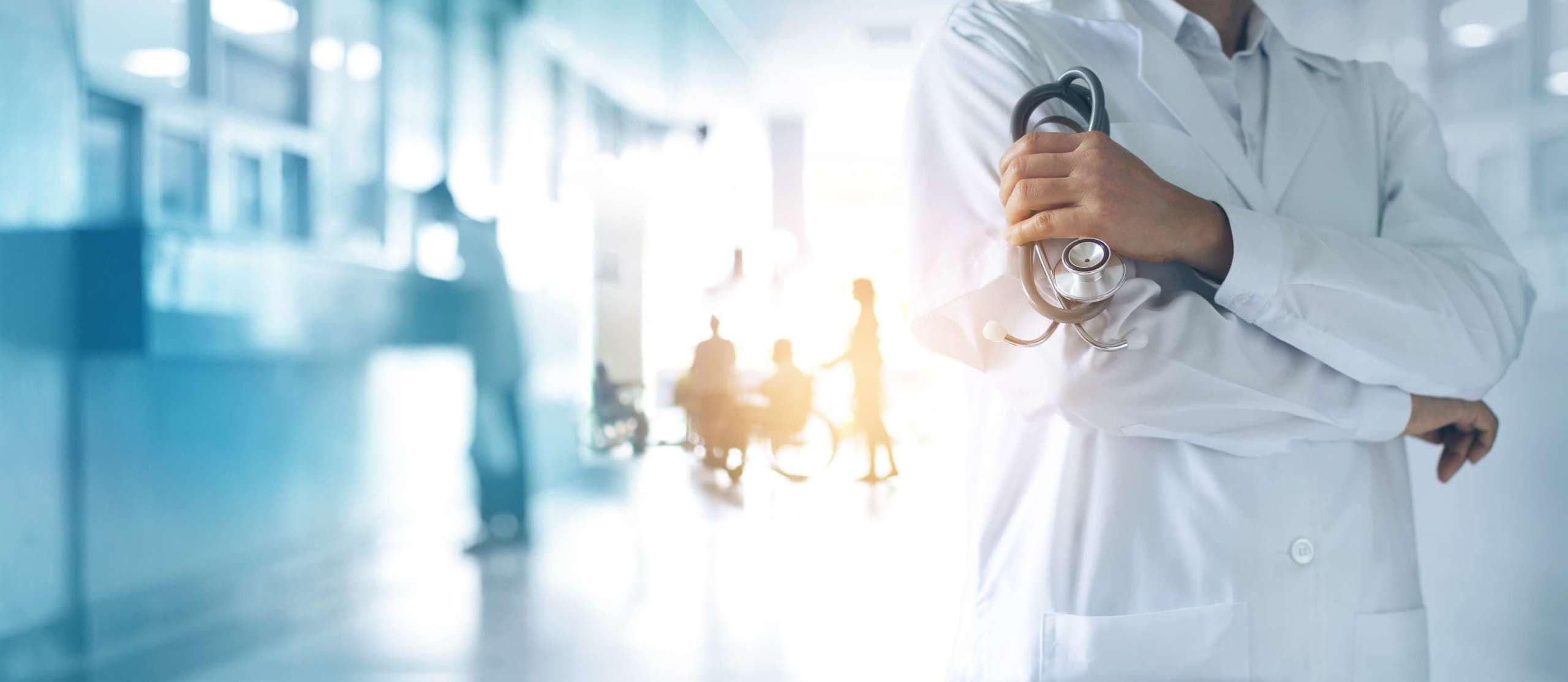 Gesundheitswesen und medizinisches Konzept. Arzt mit Stethoskop in der Hand und Patienten kommen in den Krankenhaushintergrund.