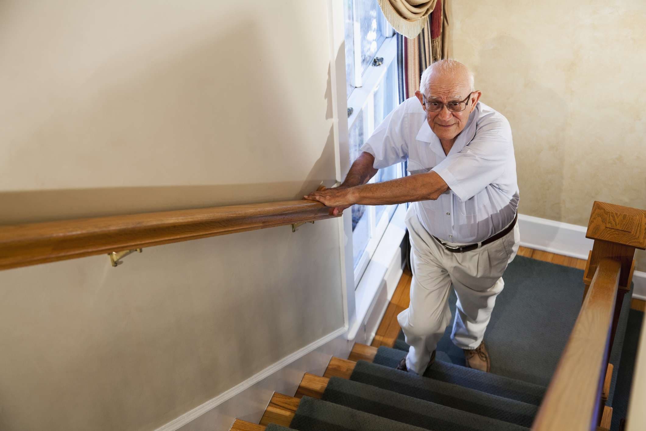 Senior Mann (80er) beim Treppensteigen.