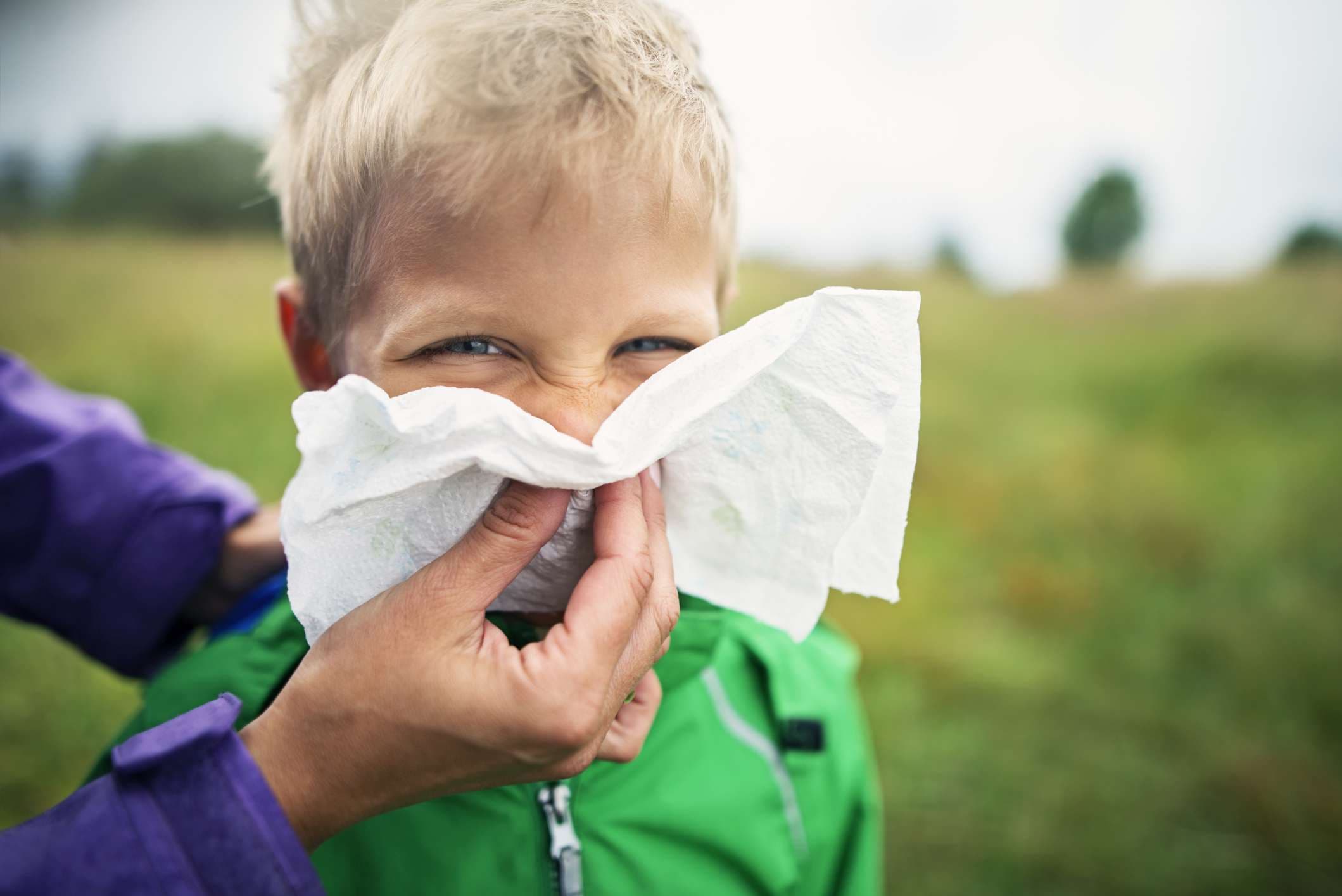 Mutter putzt die Nase eines kranken Jungen