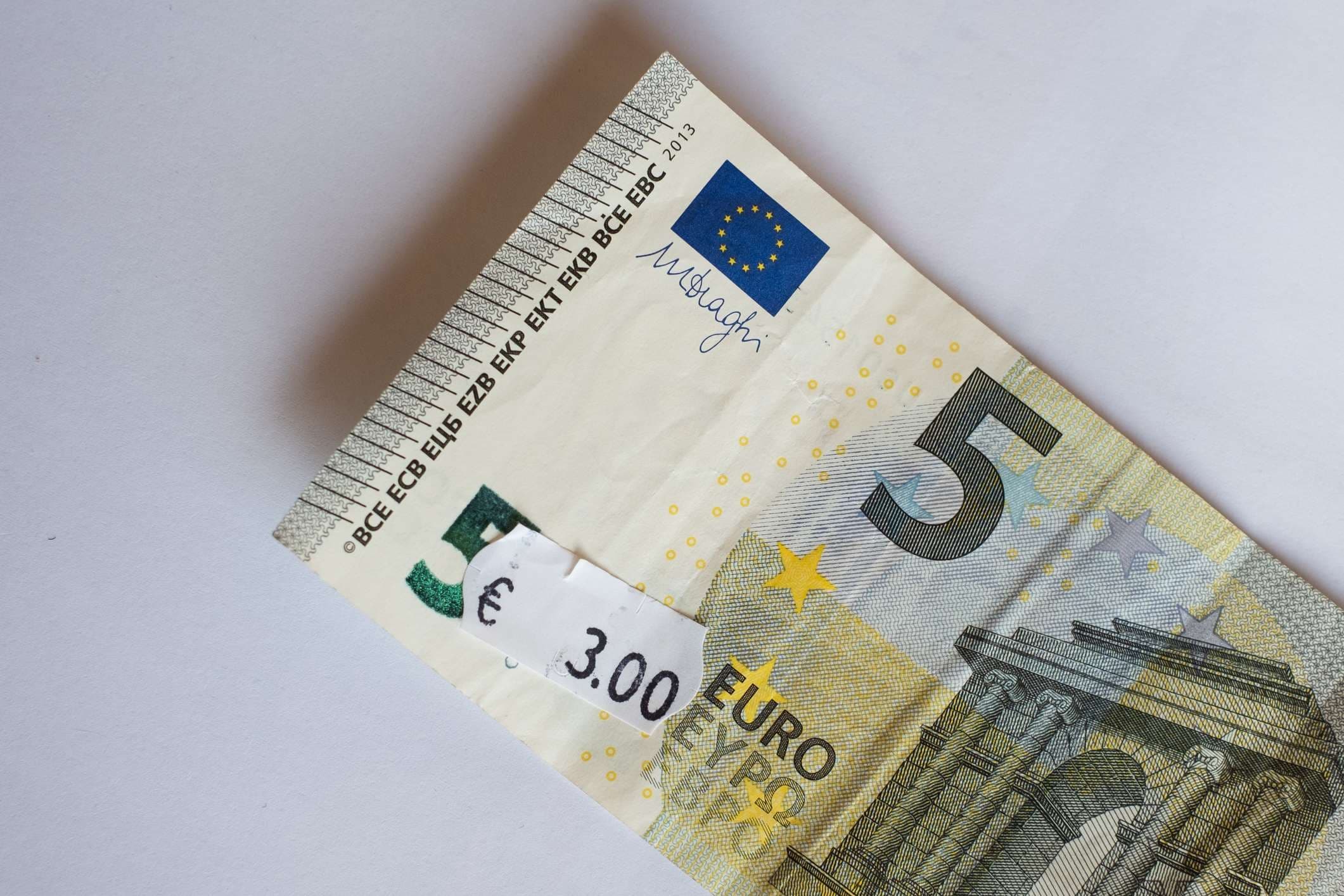 Fünf-Euro-Banknote mit drei Euro Preisschild. Selektiver Fokus auf Label.