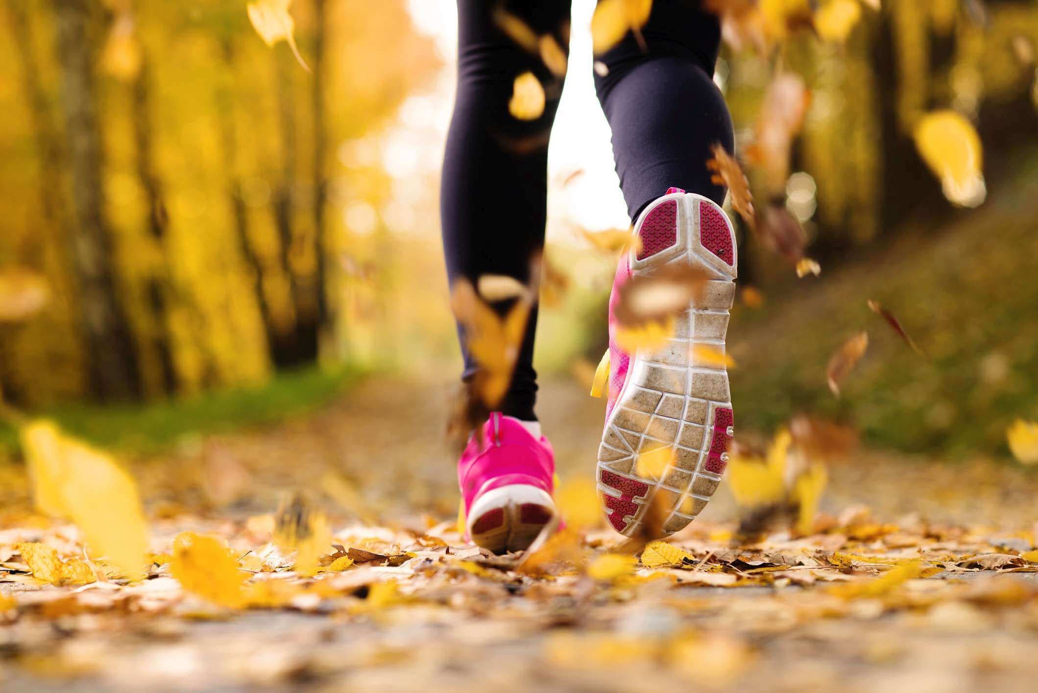 Nahaufnahme von Läuferfüßen, die im Herbst laufen, lässt Trainingsübung