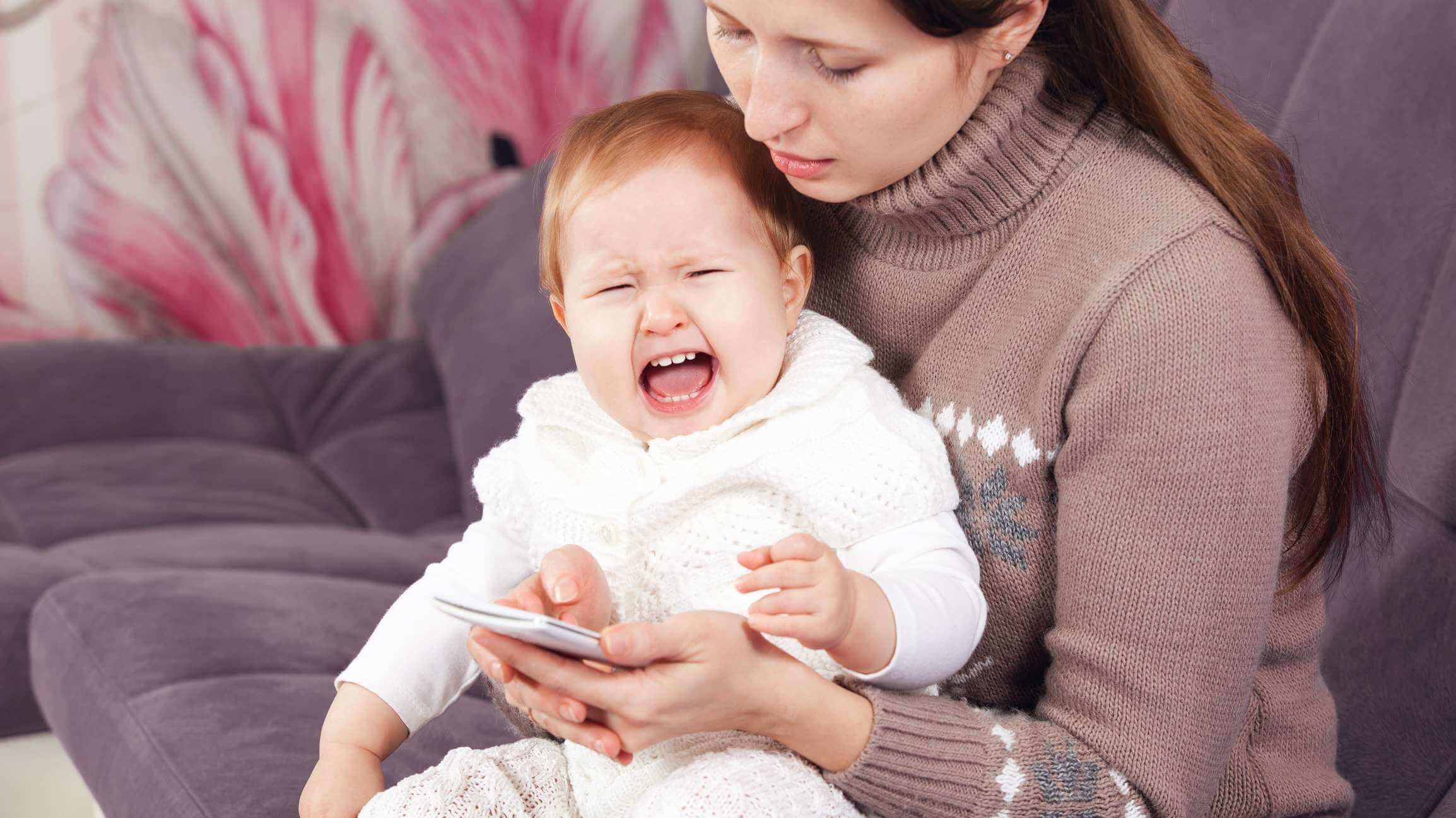 Die Frau am Telefon ignoriert das weinende Kind. Das Baby weint