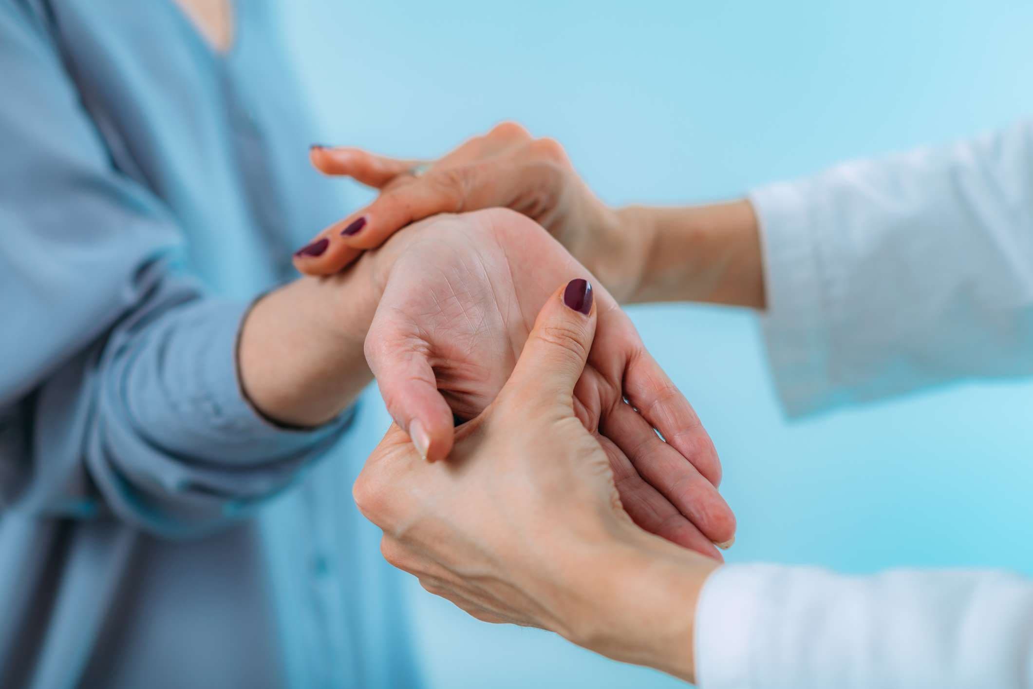 Arzt untersucht Hand eines älteren Patienten mit Schmerzen im Handgelenk. Karpaltunnelsyndrom.