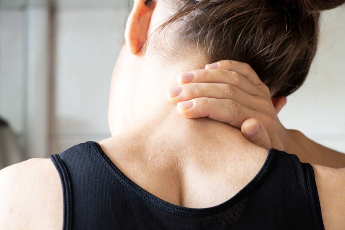 A young girl holds her hand on her neck from back pain at home,back pain